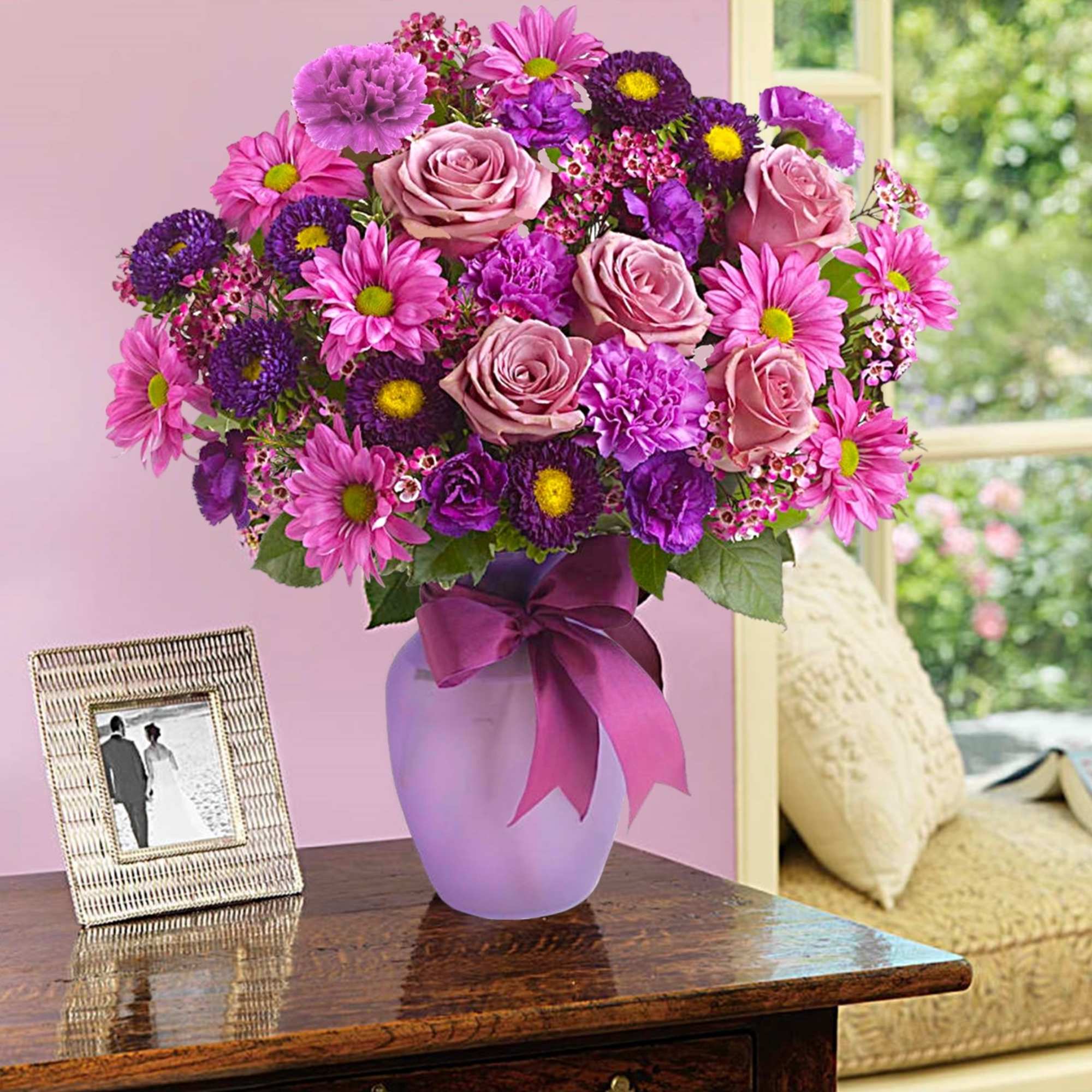 Pink and purple bouquet in a lavender vase with a ribbon