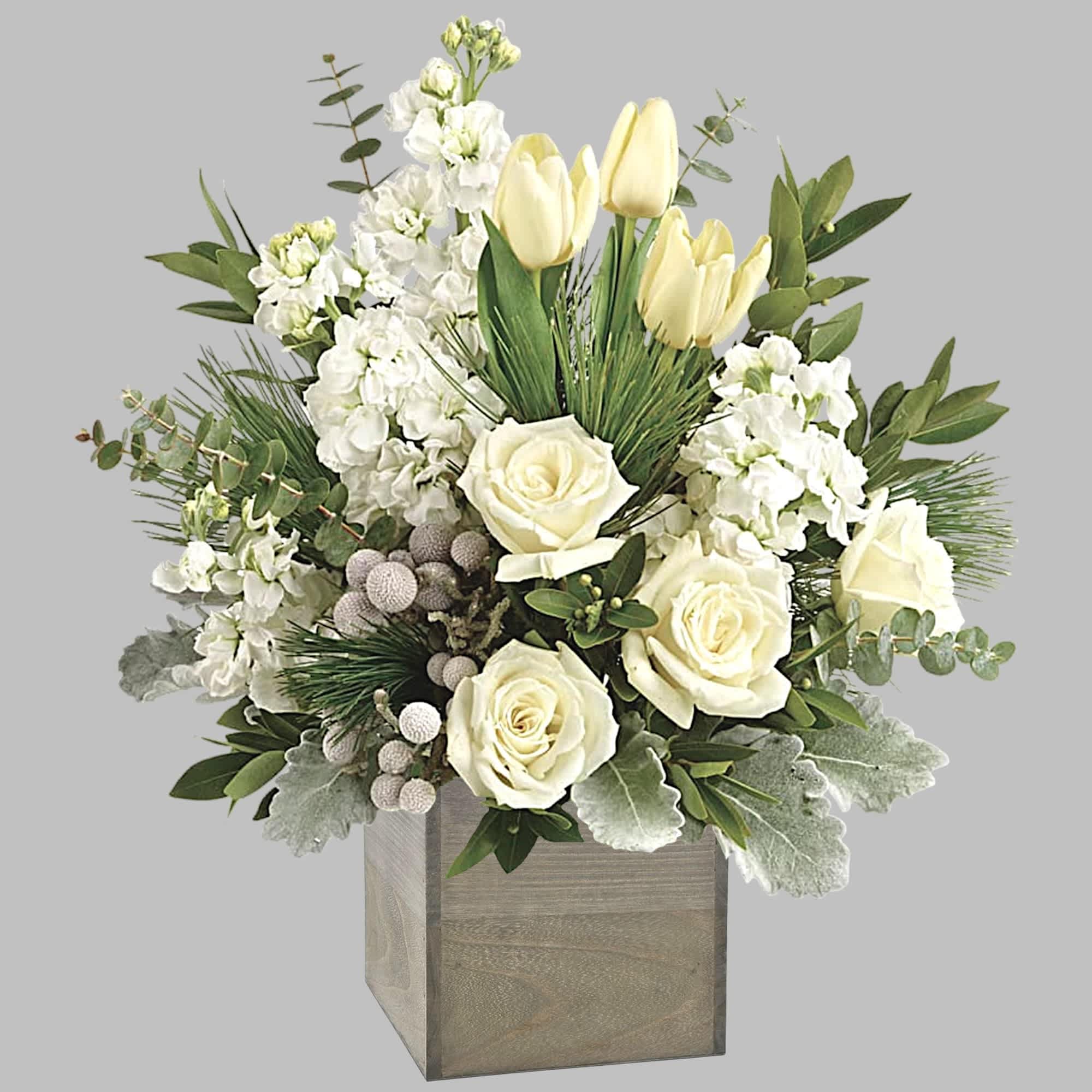 White roses and pale yellow tulips in a wooden box with greenery