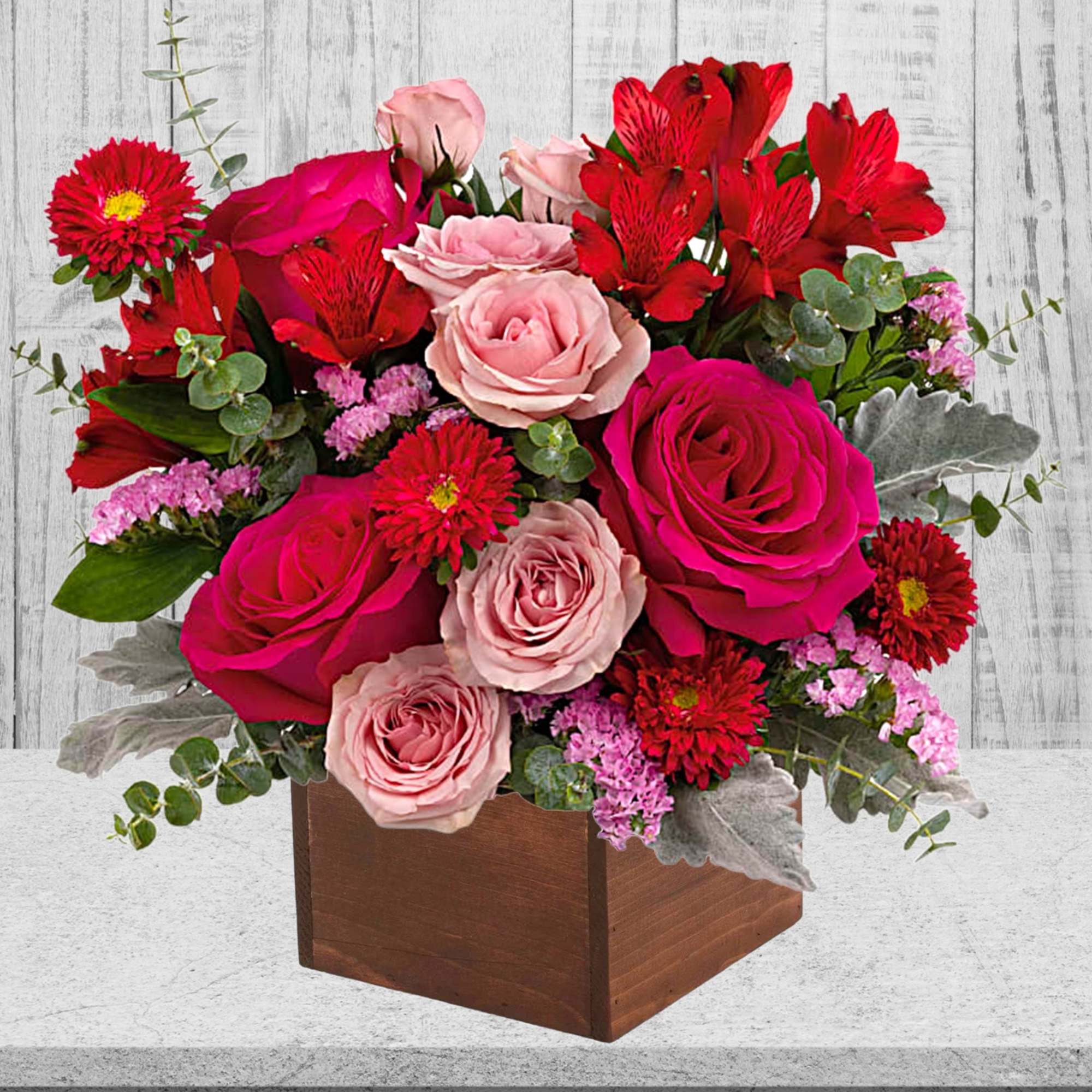 Mixed bouquet of pink and red roses in a wooden box