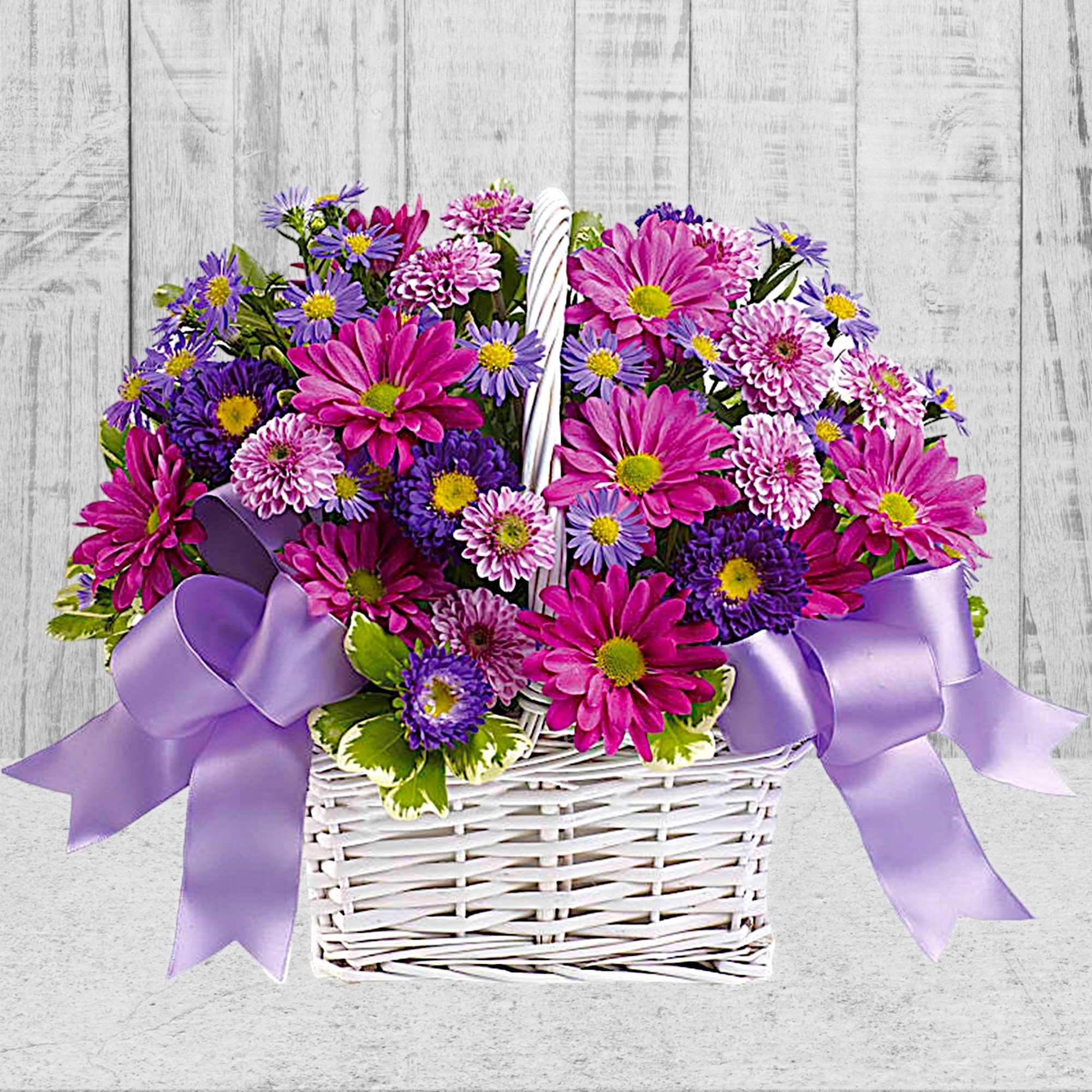 Basket of pink and purple daisies with lavender ribbons