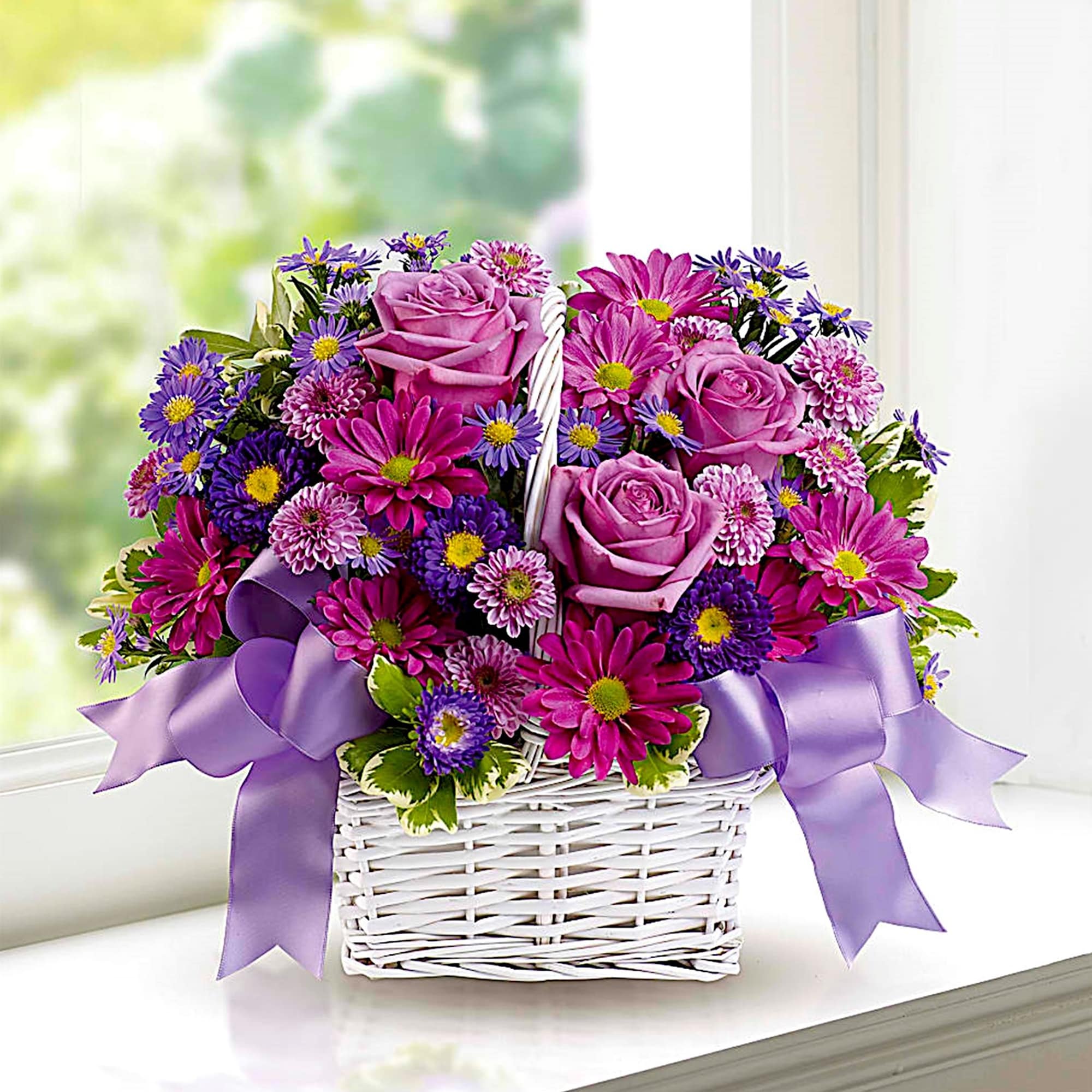 Purple roses and daisies in a white basket with lavender ribbon