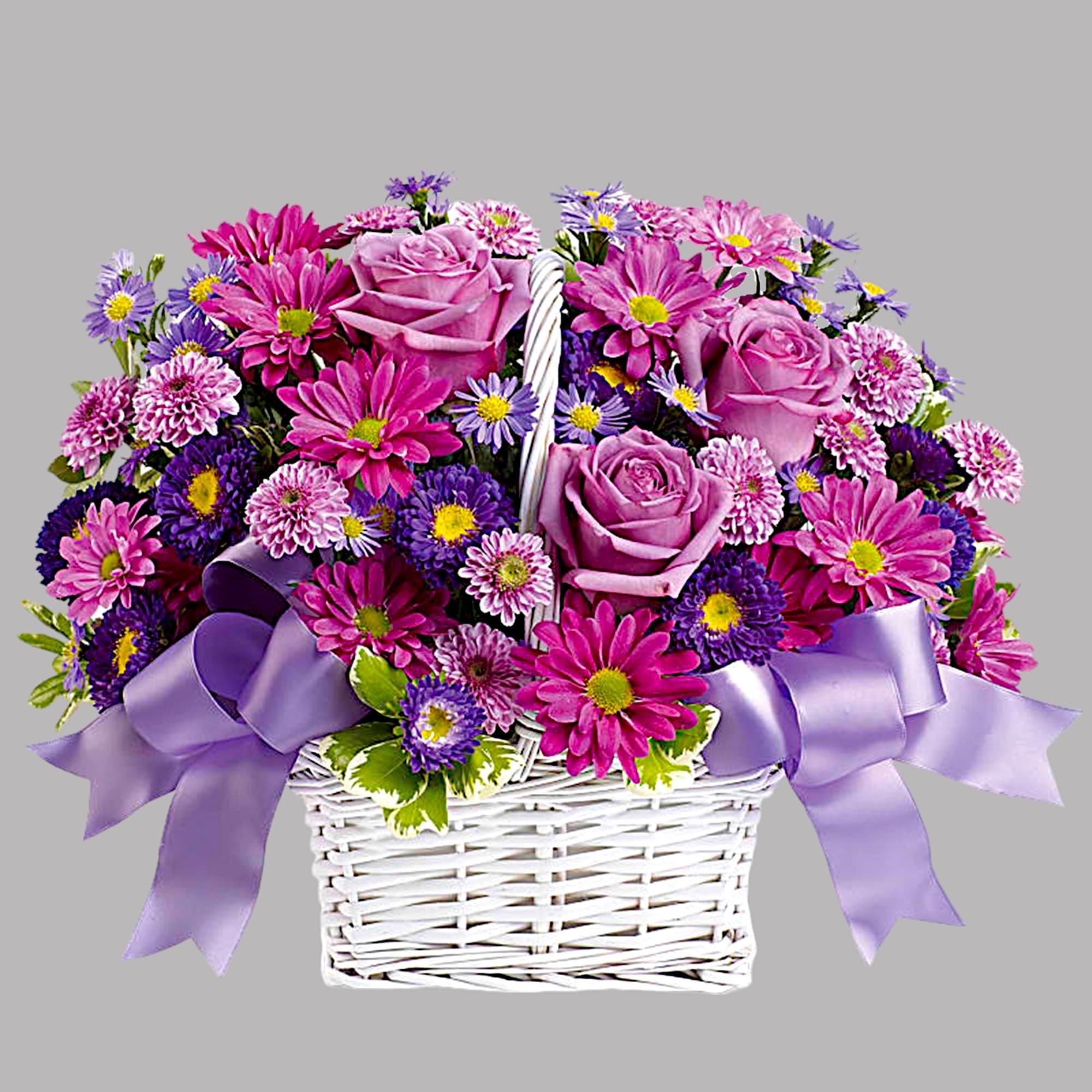Pink and purple flowers arranged in a white basket with lavender ribbon