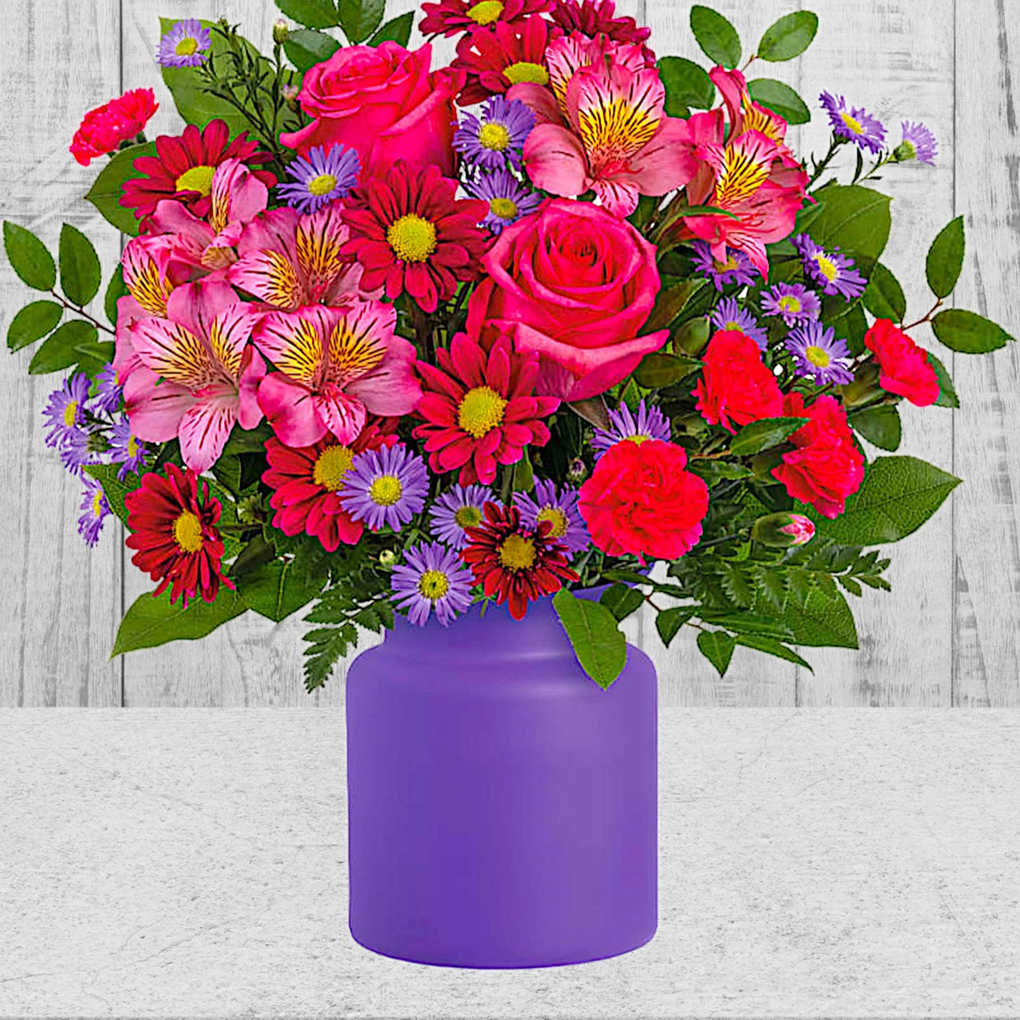 Mixed pink and purple bouquet in a purple vase