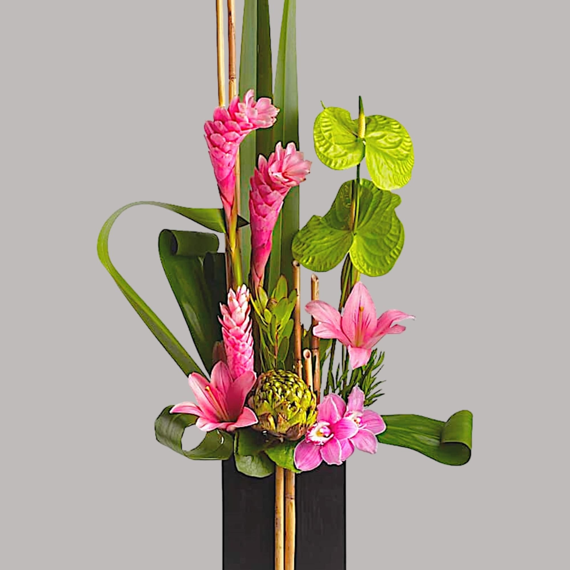 Tall tropical arrangement with pink flowers in a black vase