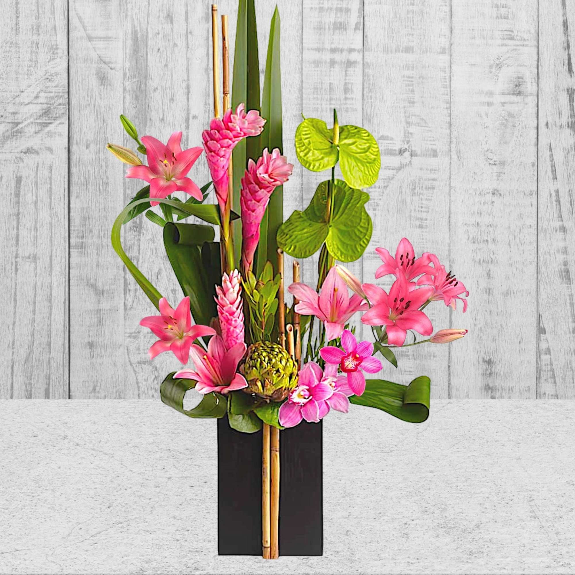 Pink tropical flowers arranged in a tall black vase
