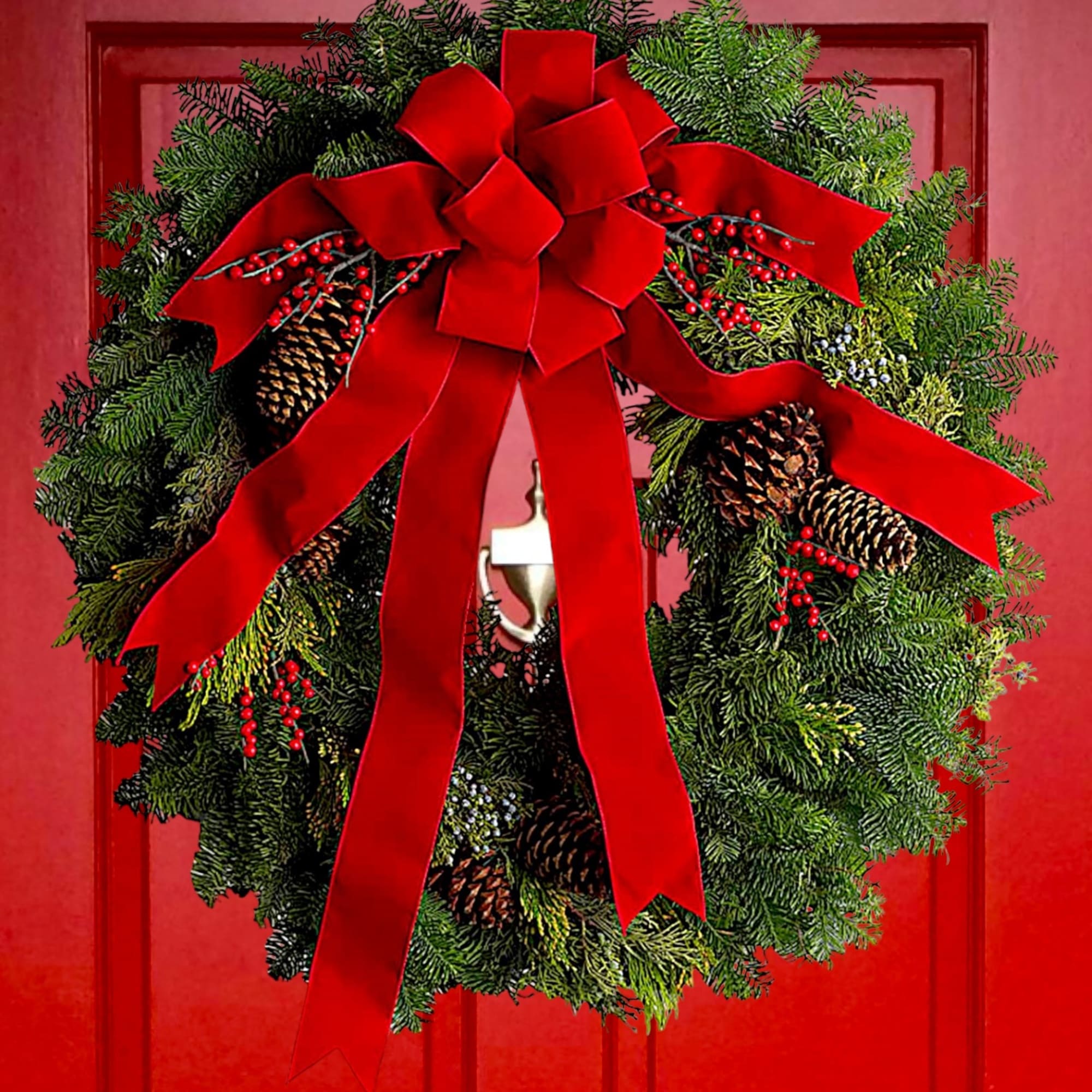 Christmas wreath with red bow and pinecones on a red door