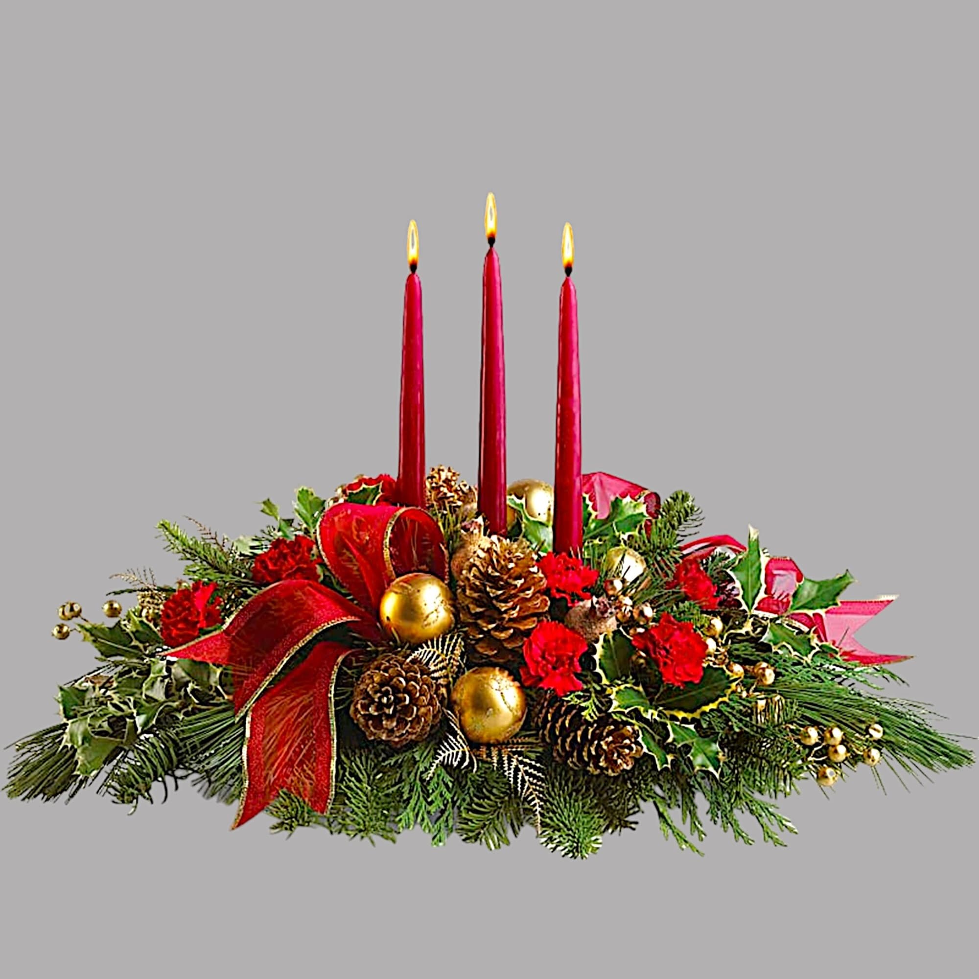 Holiday centerpiece with three red candles, pinecones, and red flowers