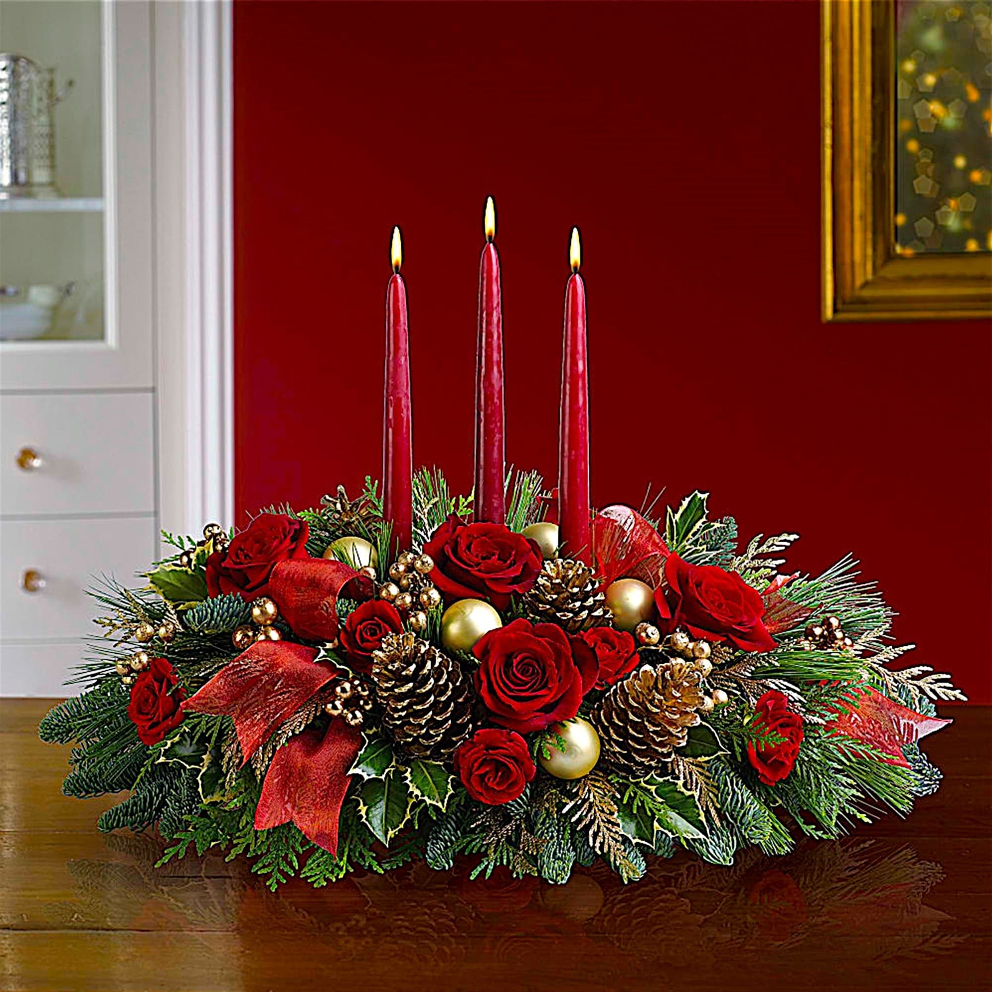Holiday centerpiece with red roses and three lit red candles