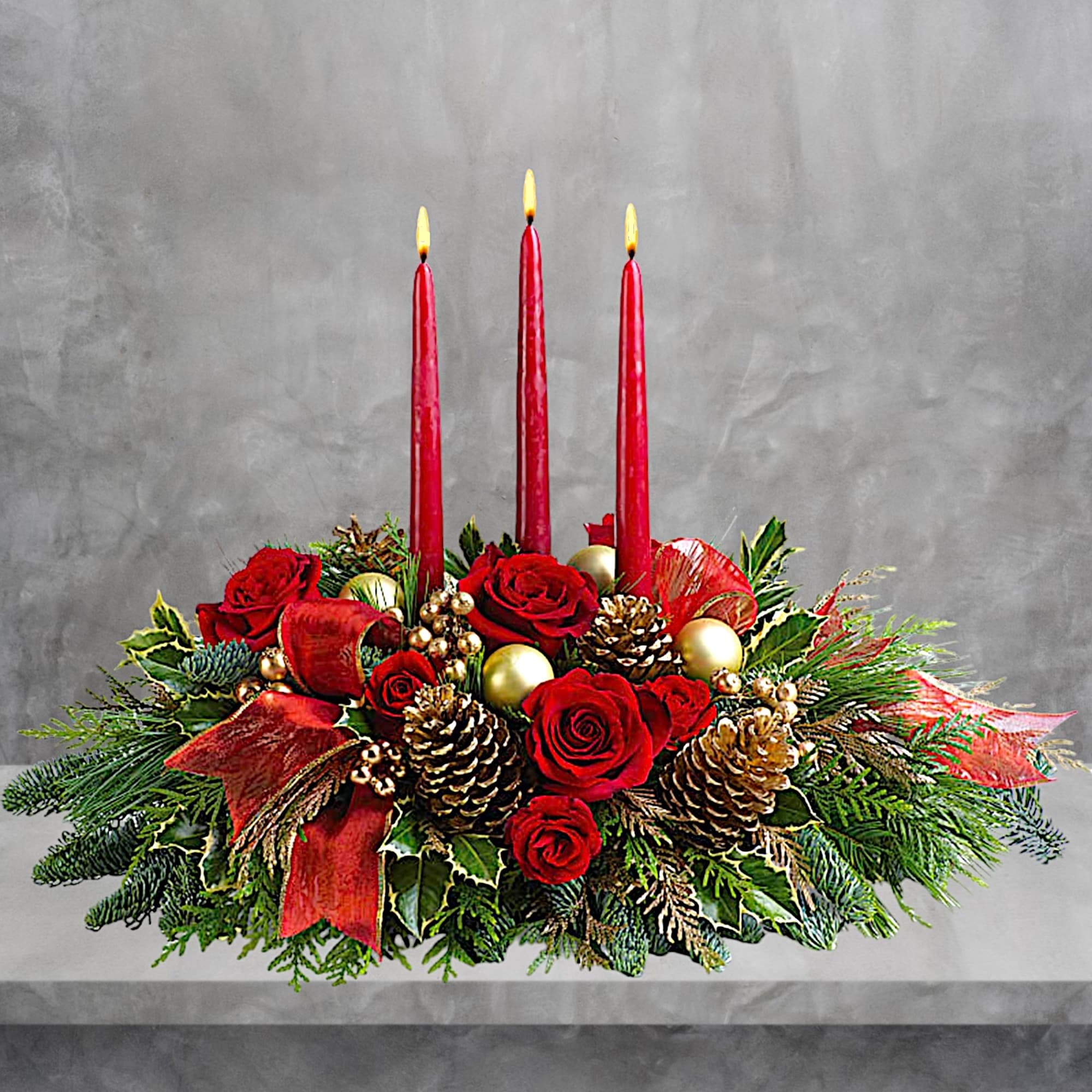 Holiday centerpiece with red roses, pinecones, and three red candles