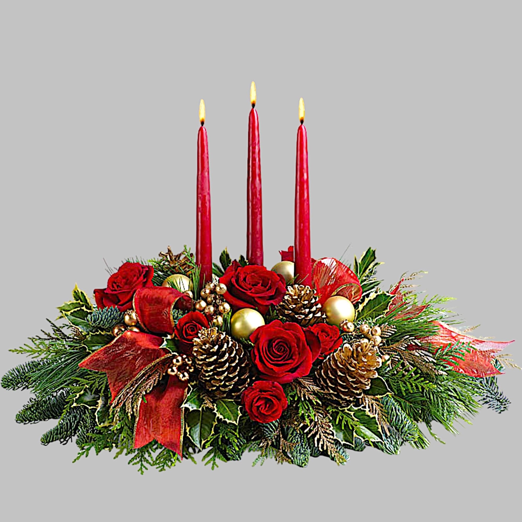Red rose centerpiece with three lit candles and pinecones