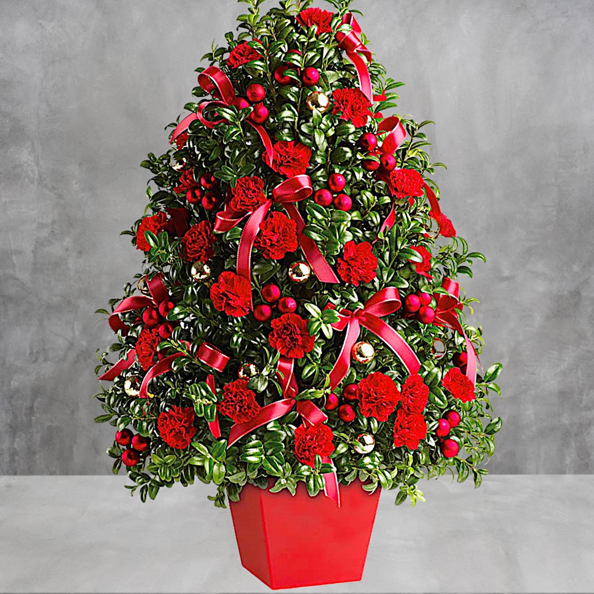 Red carnations and ribbons arranged in a cone-shaped planter