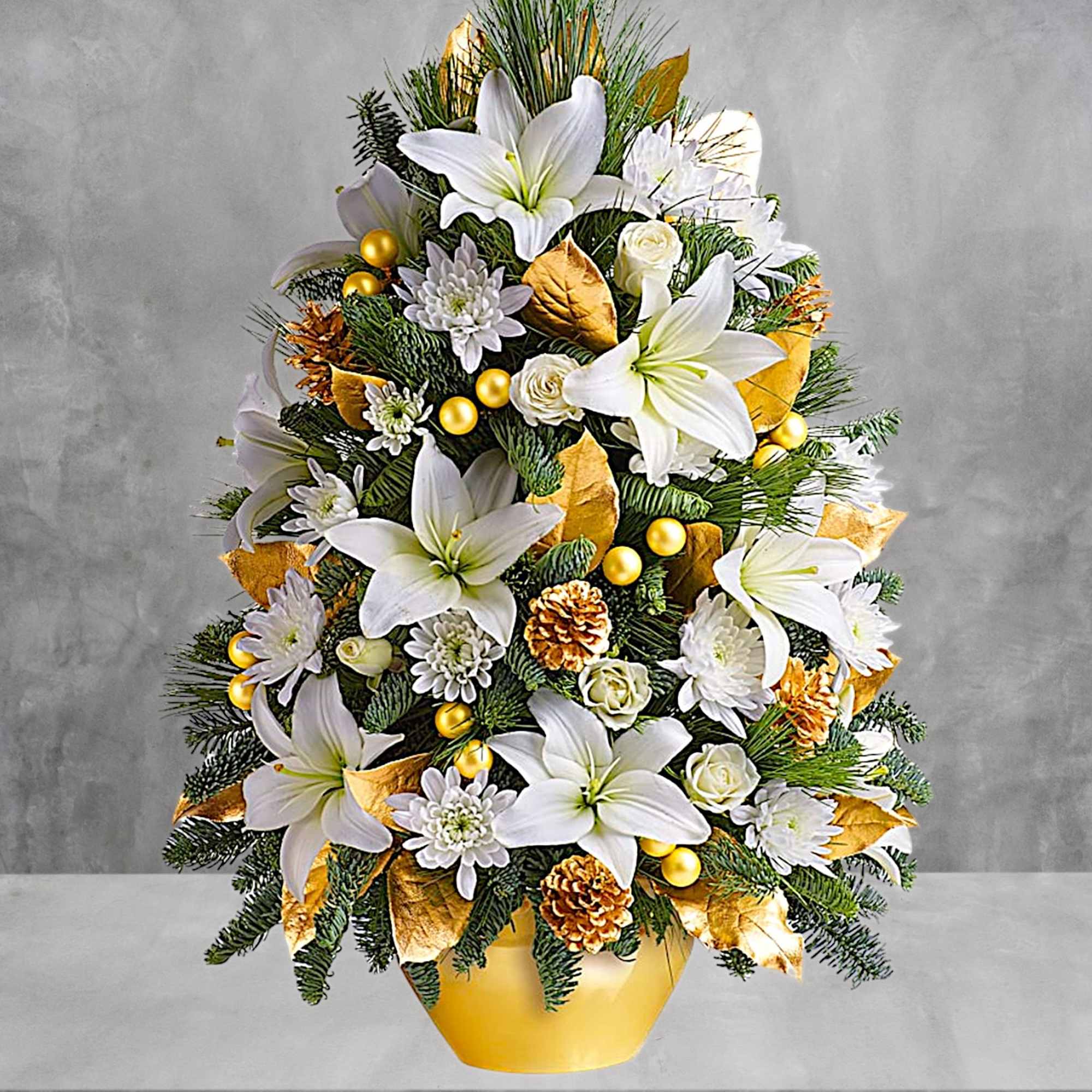 White lilies and small white flowers arranged in a gold vase