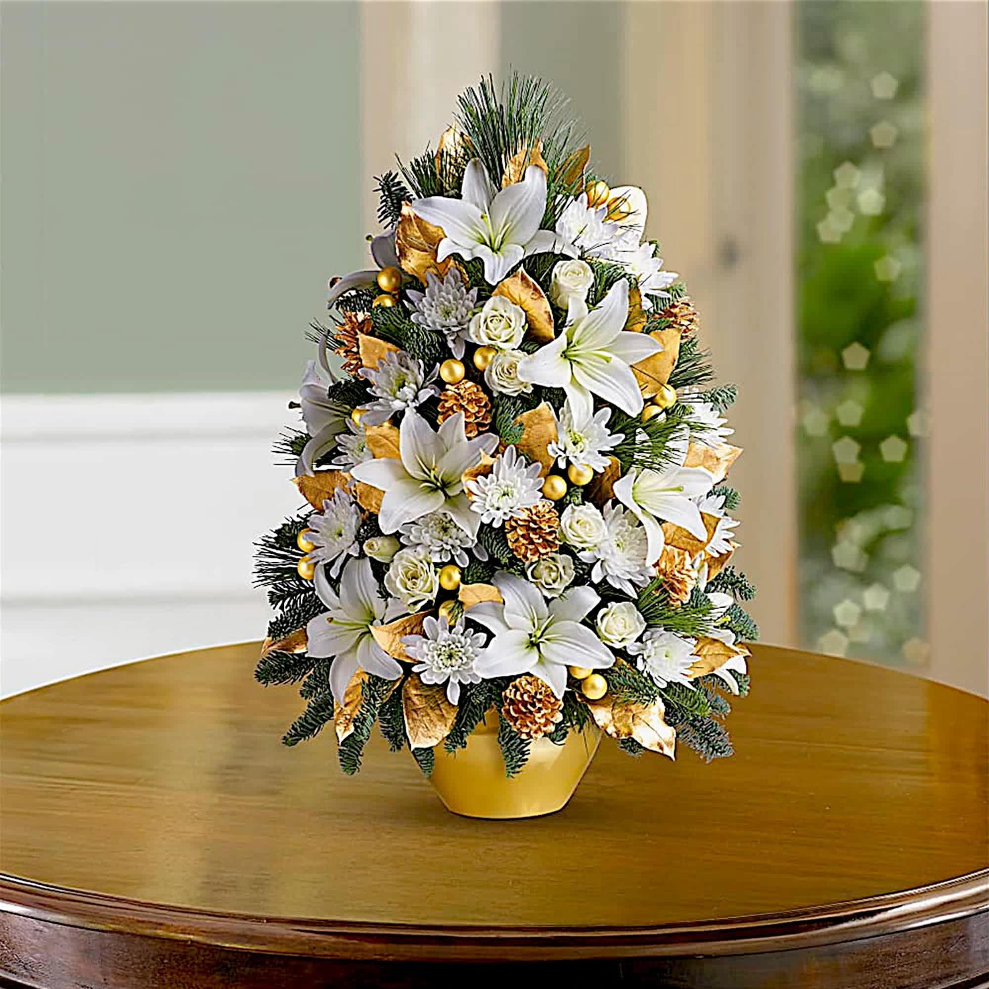 White lilies and daisies in a gold vase with pinecones and gold accents