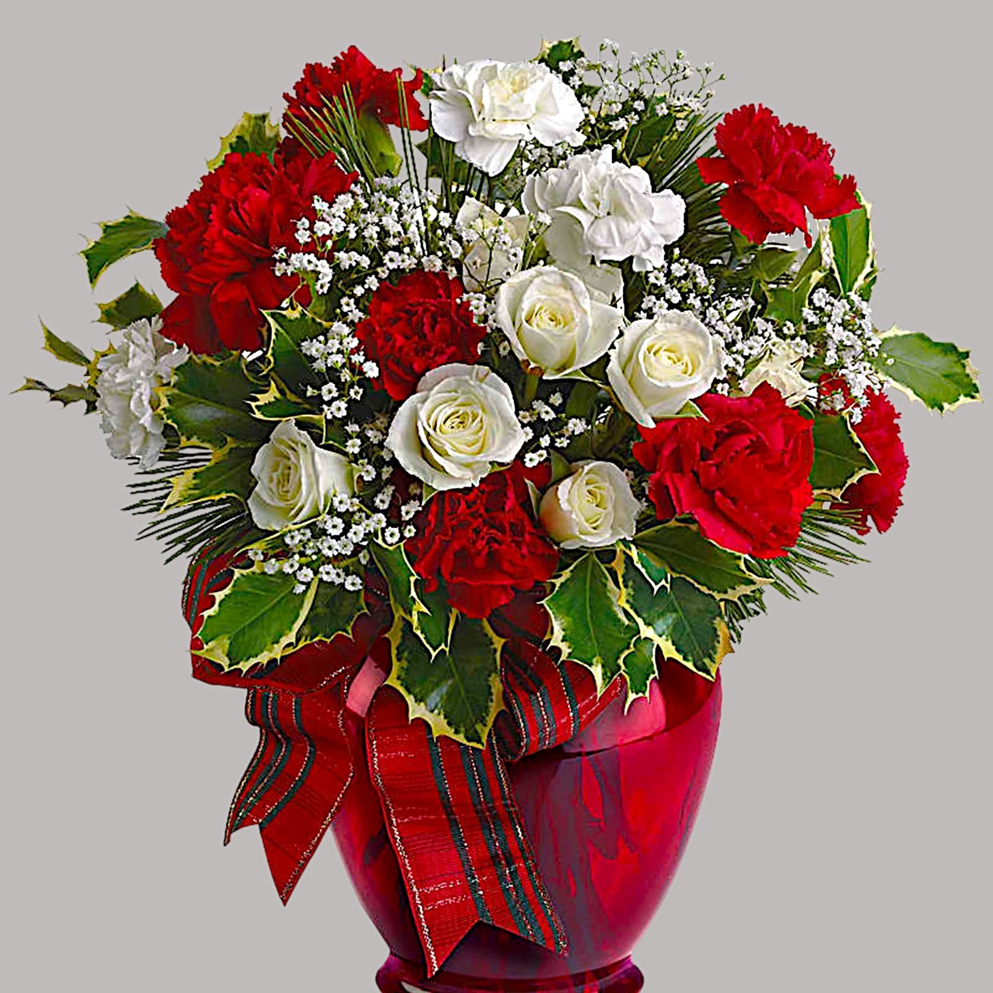 Red and white roses with carnations in a red glass vase