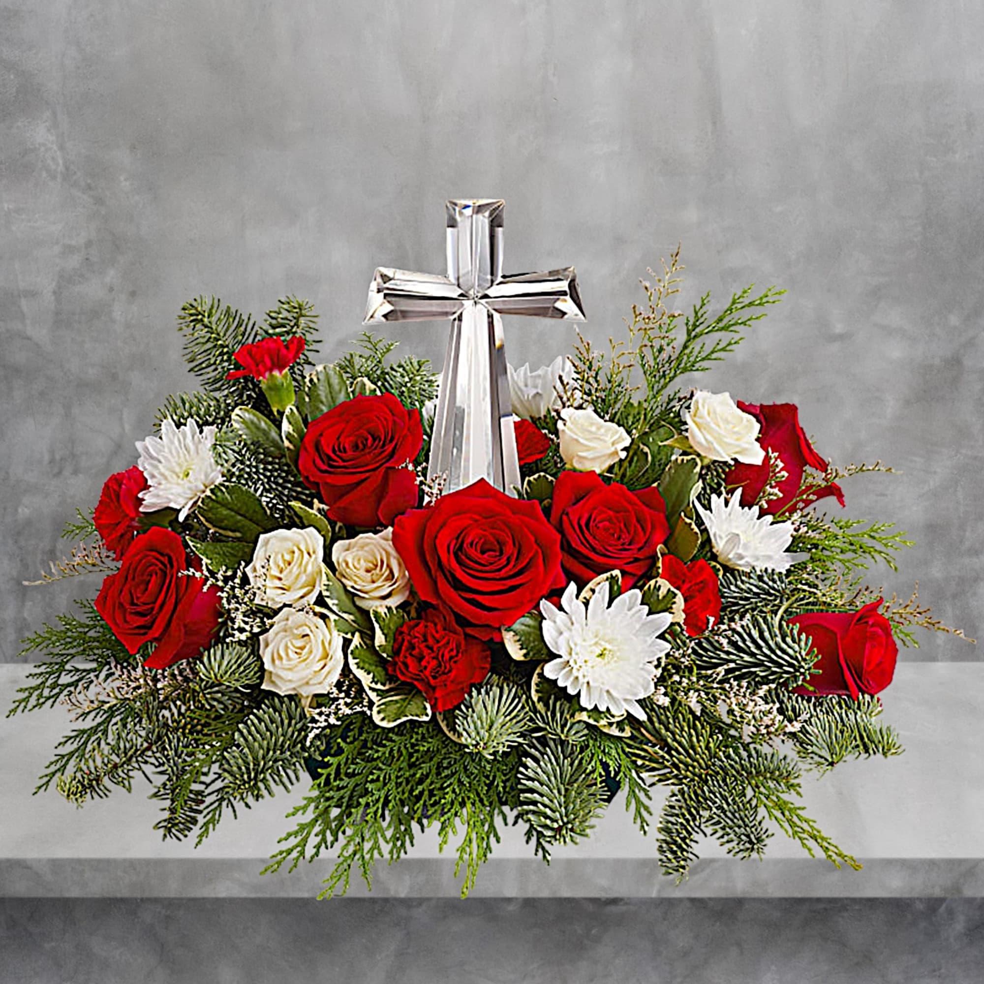Red and white roses arranged around a silver cross
