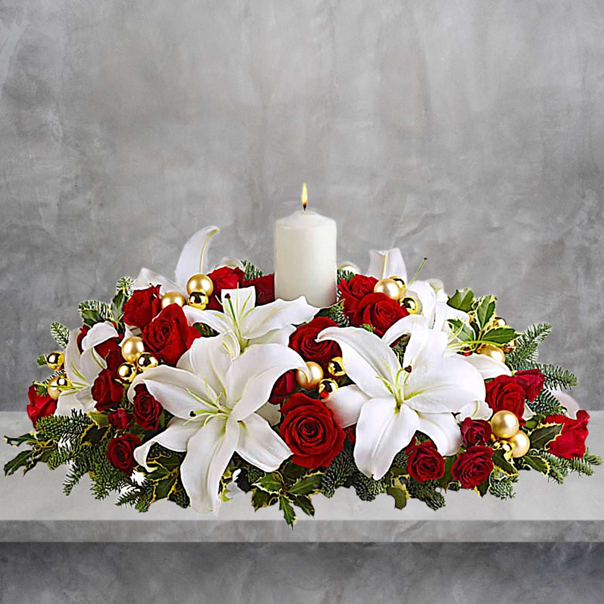 Red roses and white lilies arranged around a lit white candle, photo 2 of 4