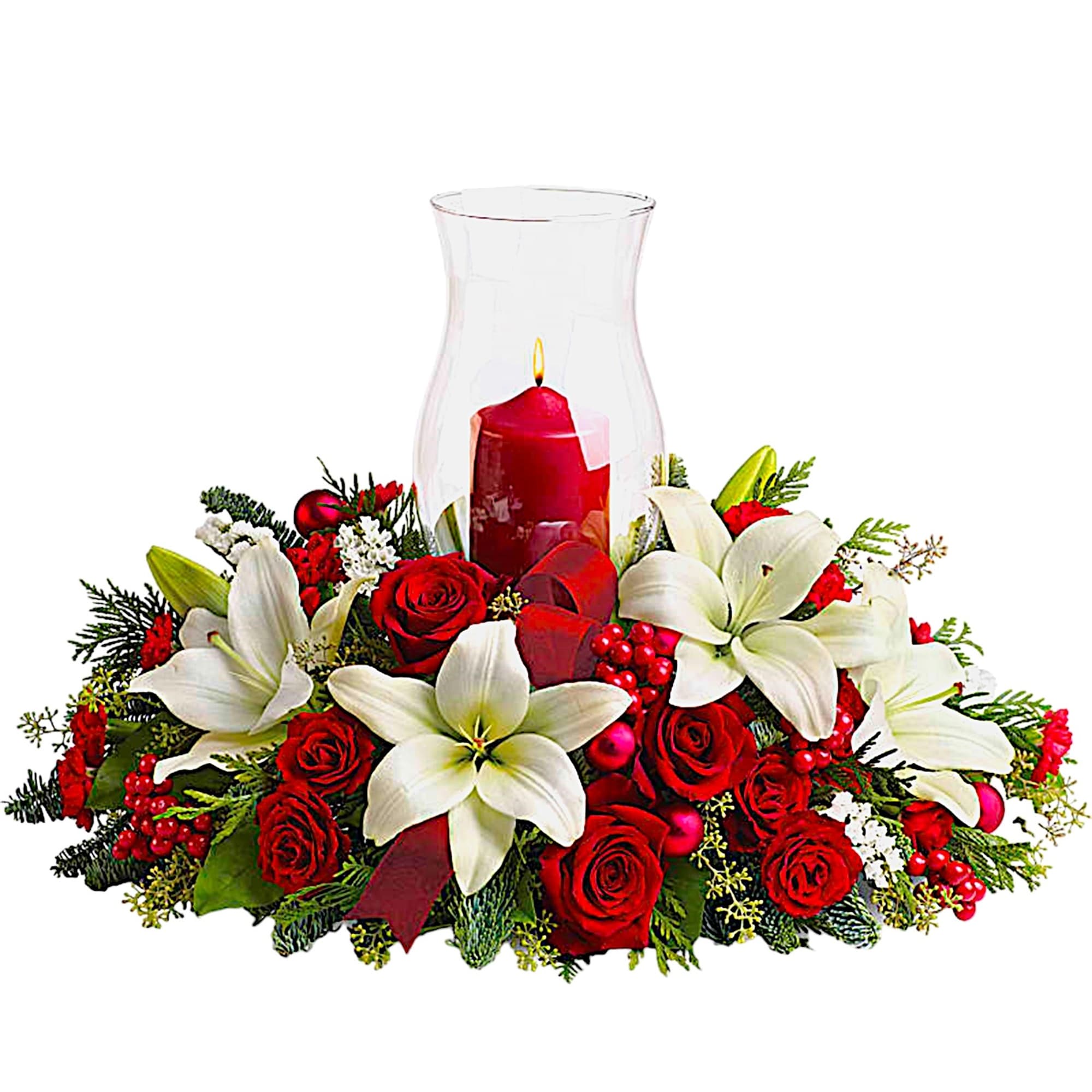 Red roses and white lilies arranged around a glass hurricane candle holder