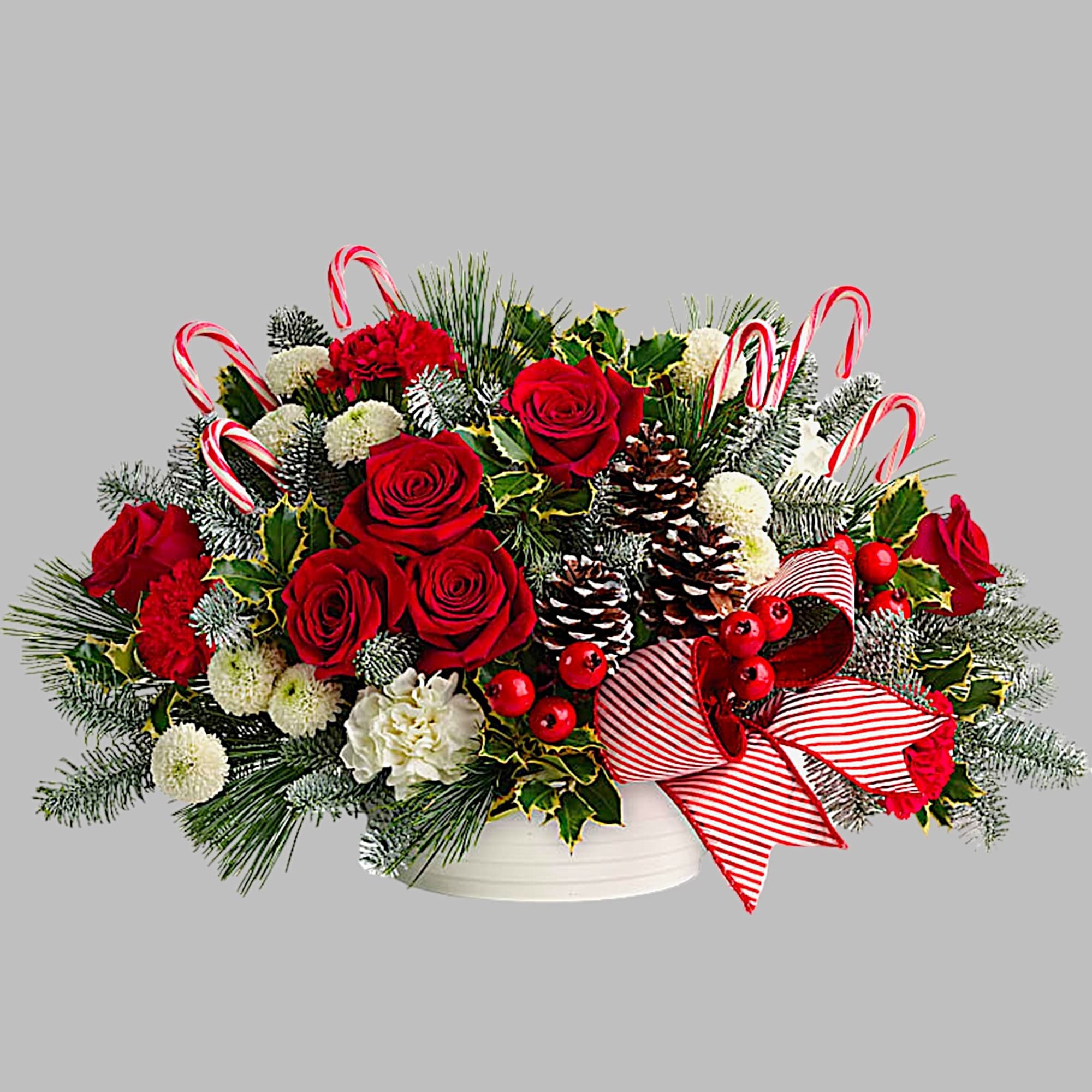 Christmas arrangement of red roses and white flowers in a white bowl