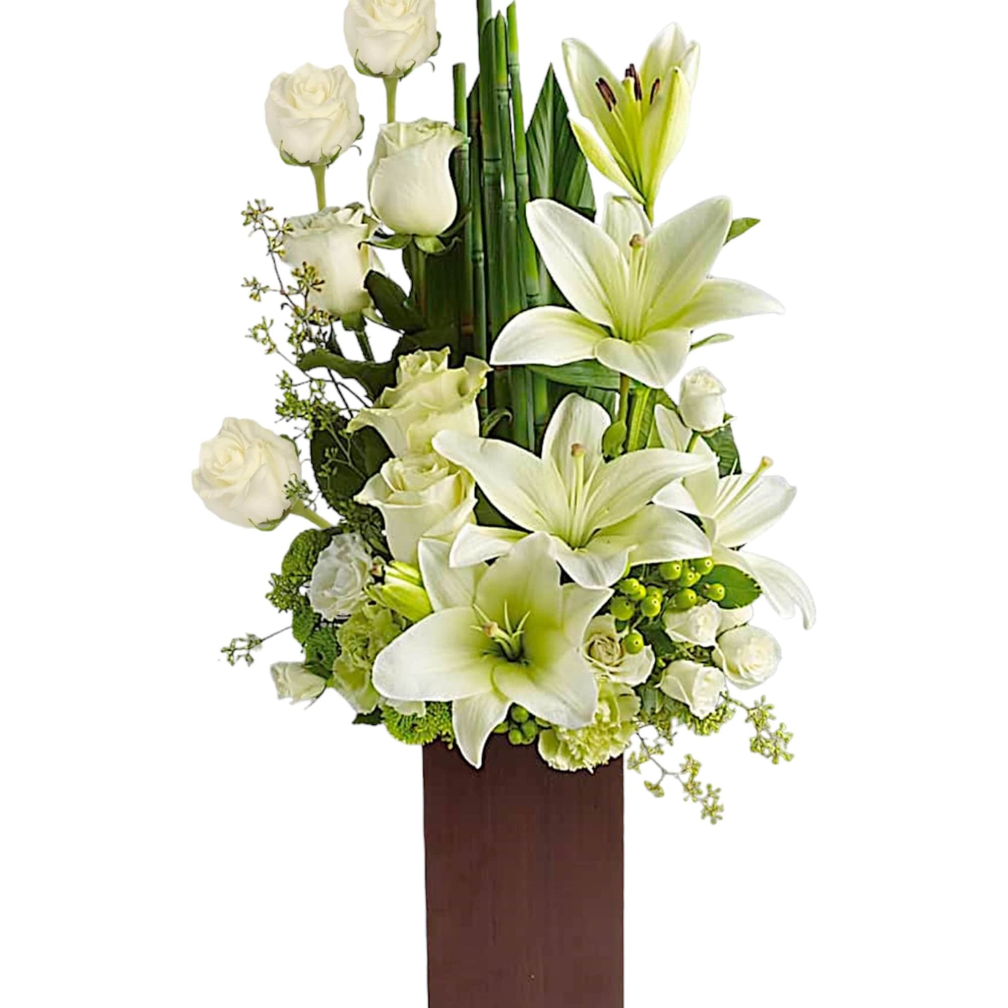 White roses and lilies arranged in a tall wooden vase