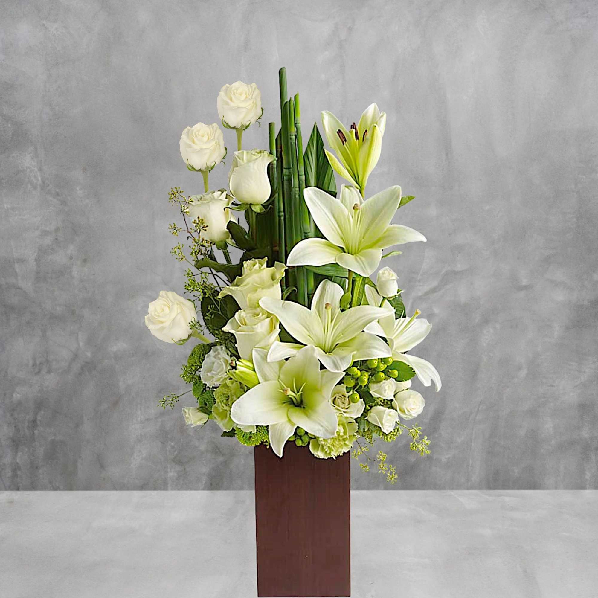 White lilies and roses arranged in a tall wooden vase, photo 2 of 3