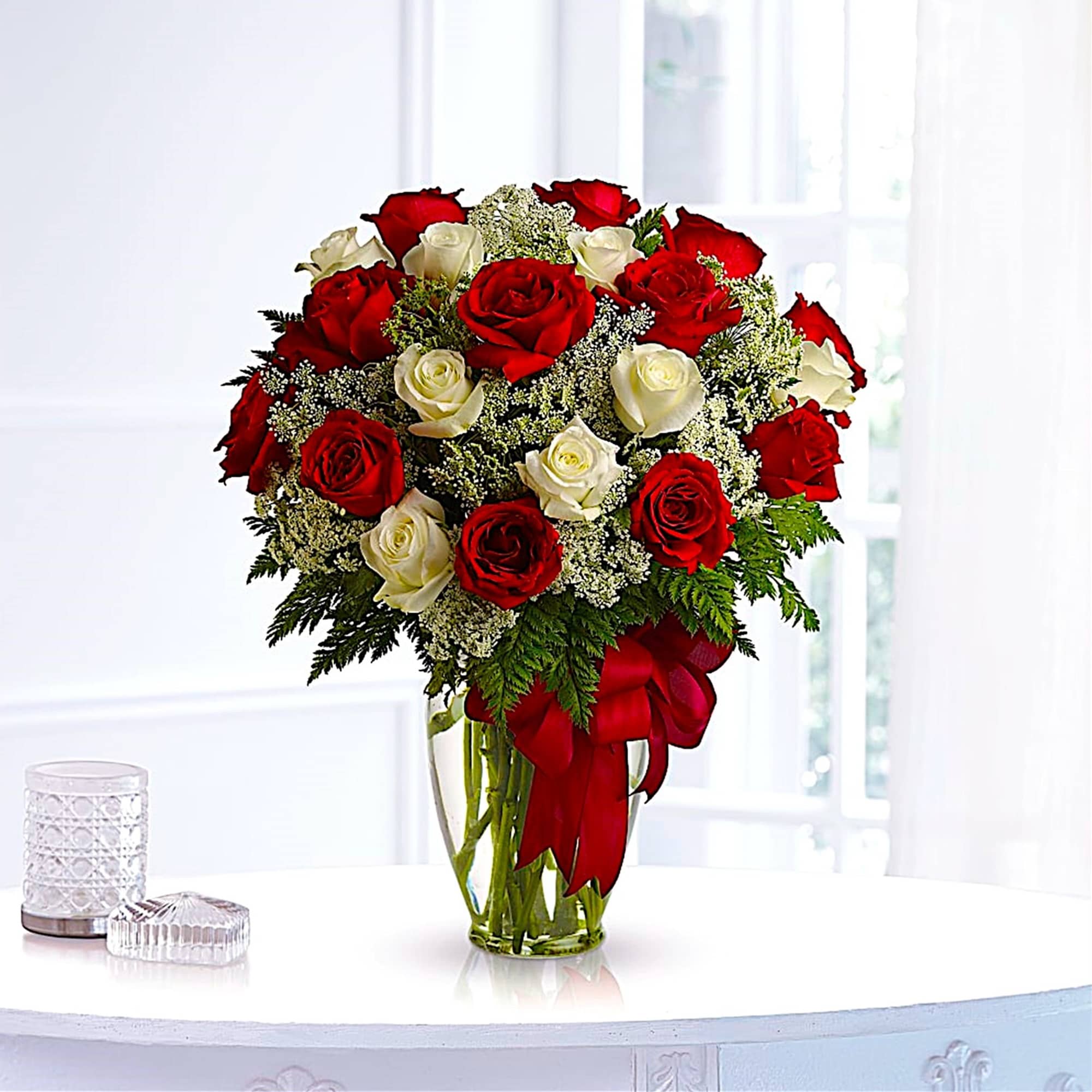 Red and white roses arranged in a clear glass vase with a red ribbon, photo 3 of 5