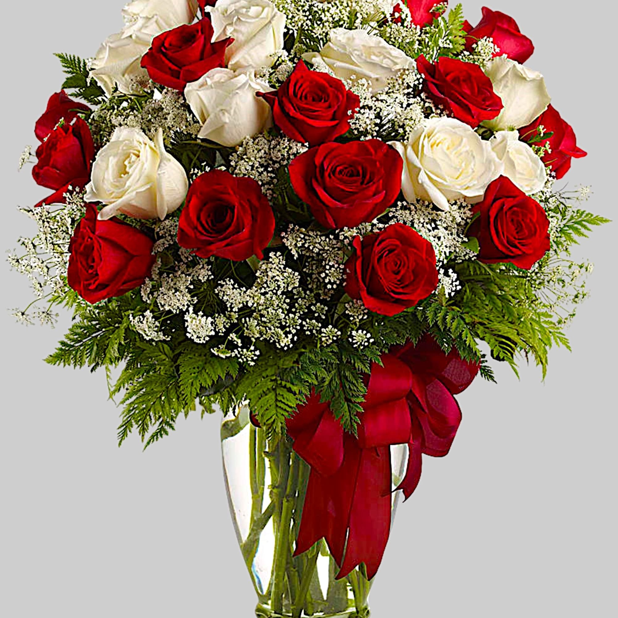 Red and white roses in a clear glass vase with a red ribbon, photo 5 of 5