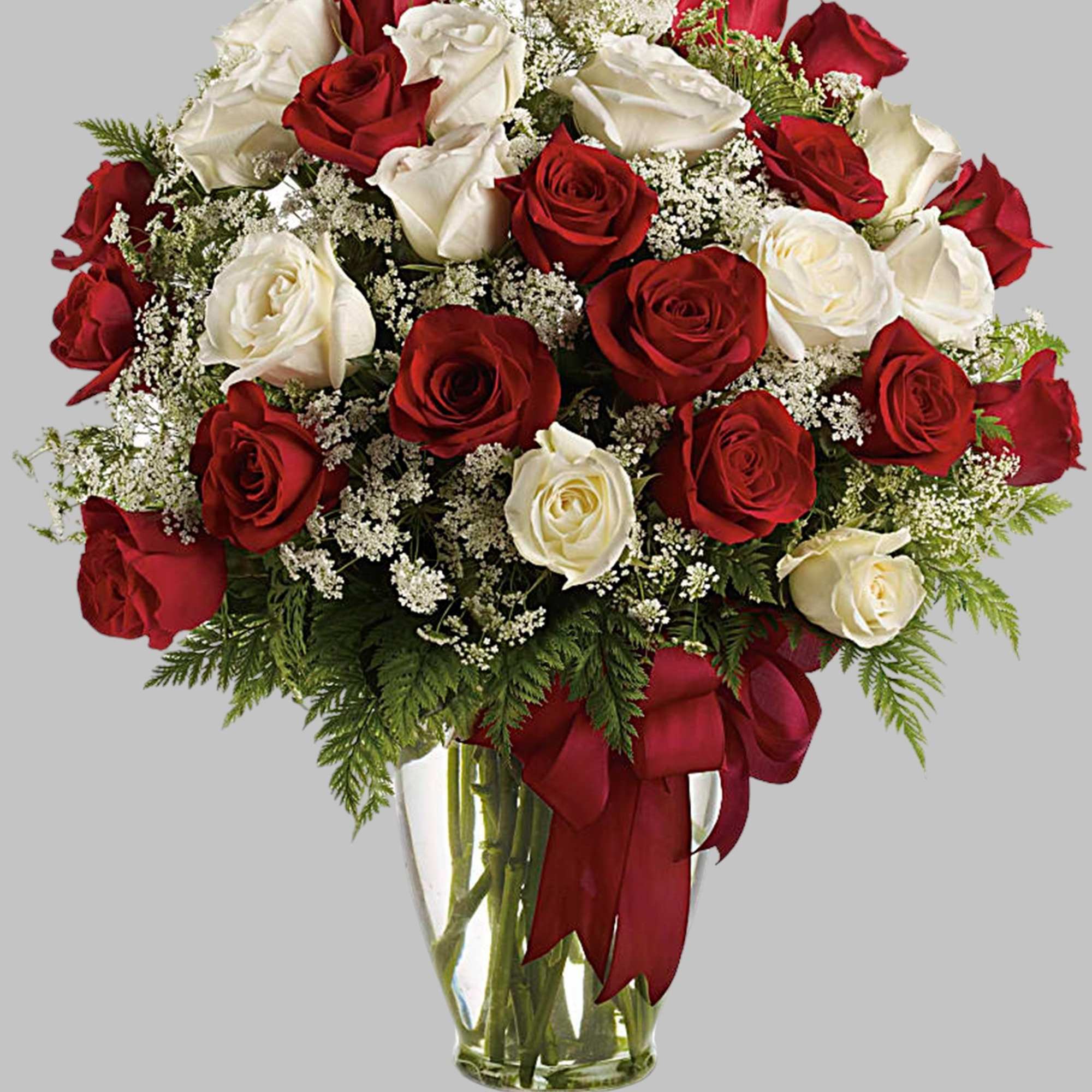 Red and white roses in a clear glass vase with a red ribbon, photo 5 of 5