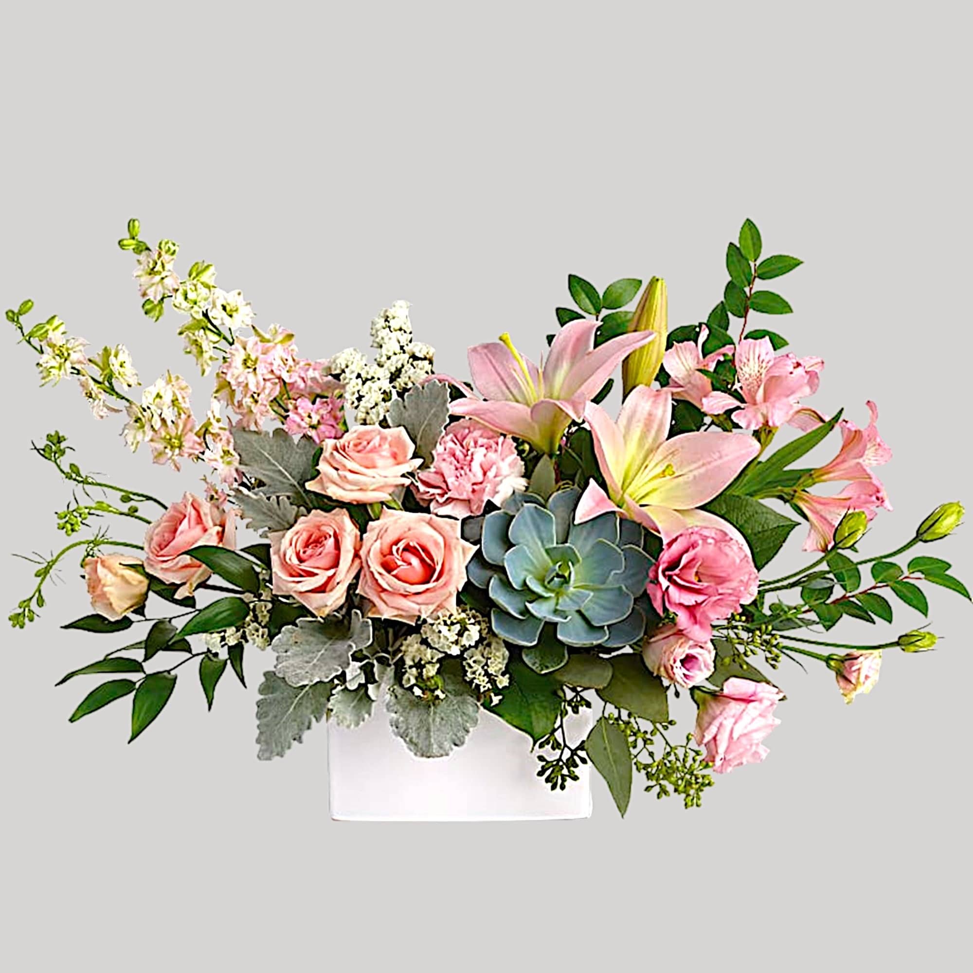 Pink roses and lilies arranged in a white vase
