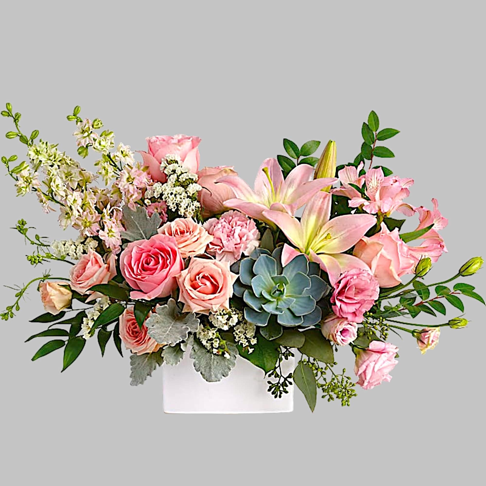 Pink roses and lilies arranged in a white vase with greenery