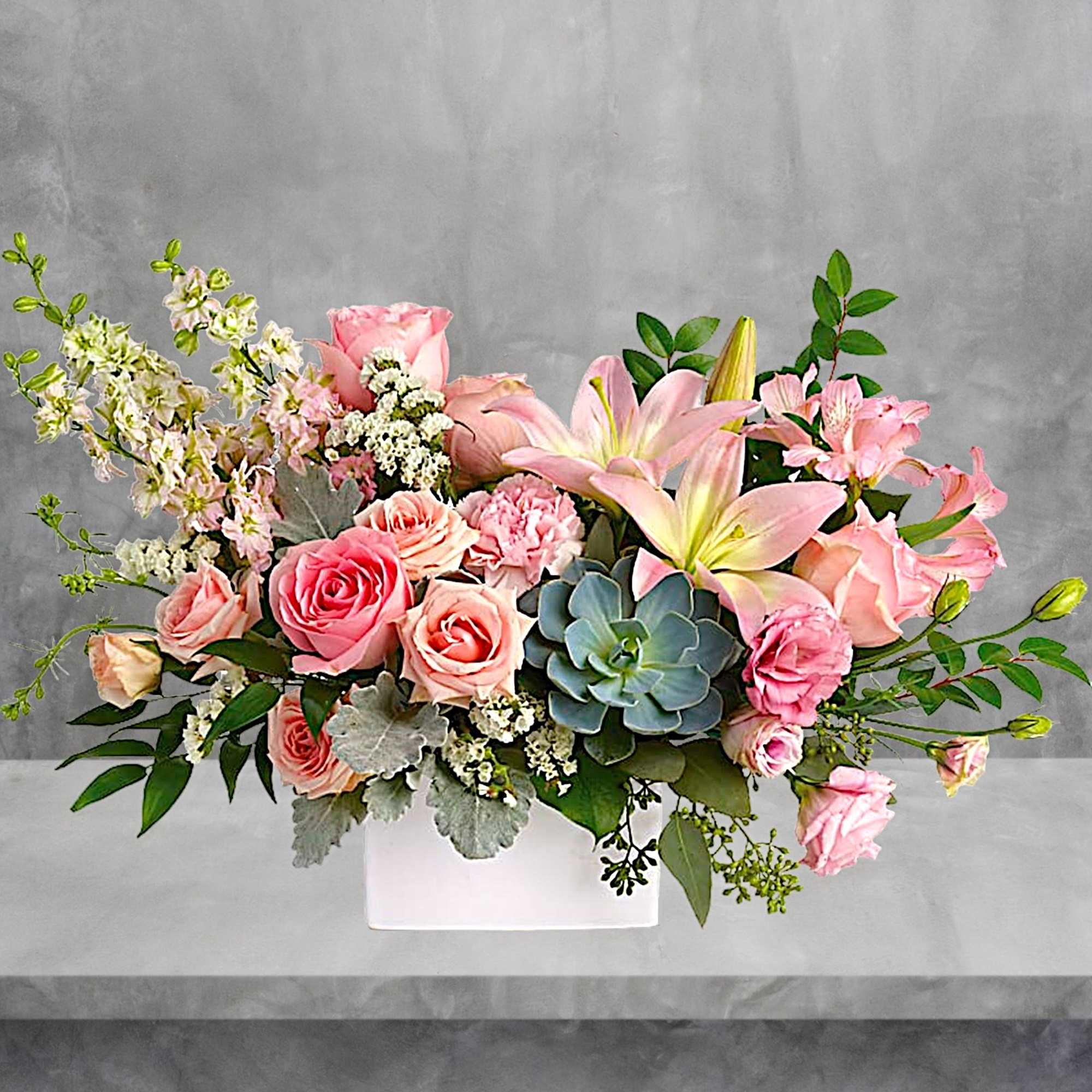 Pink roses and lilies in a white rectangular vase