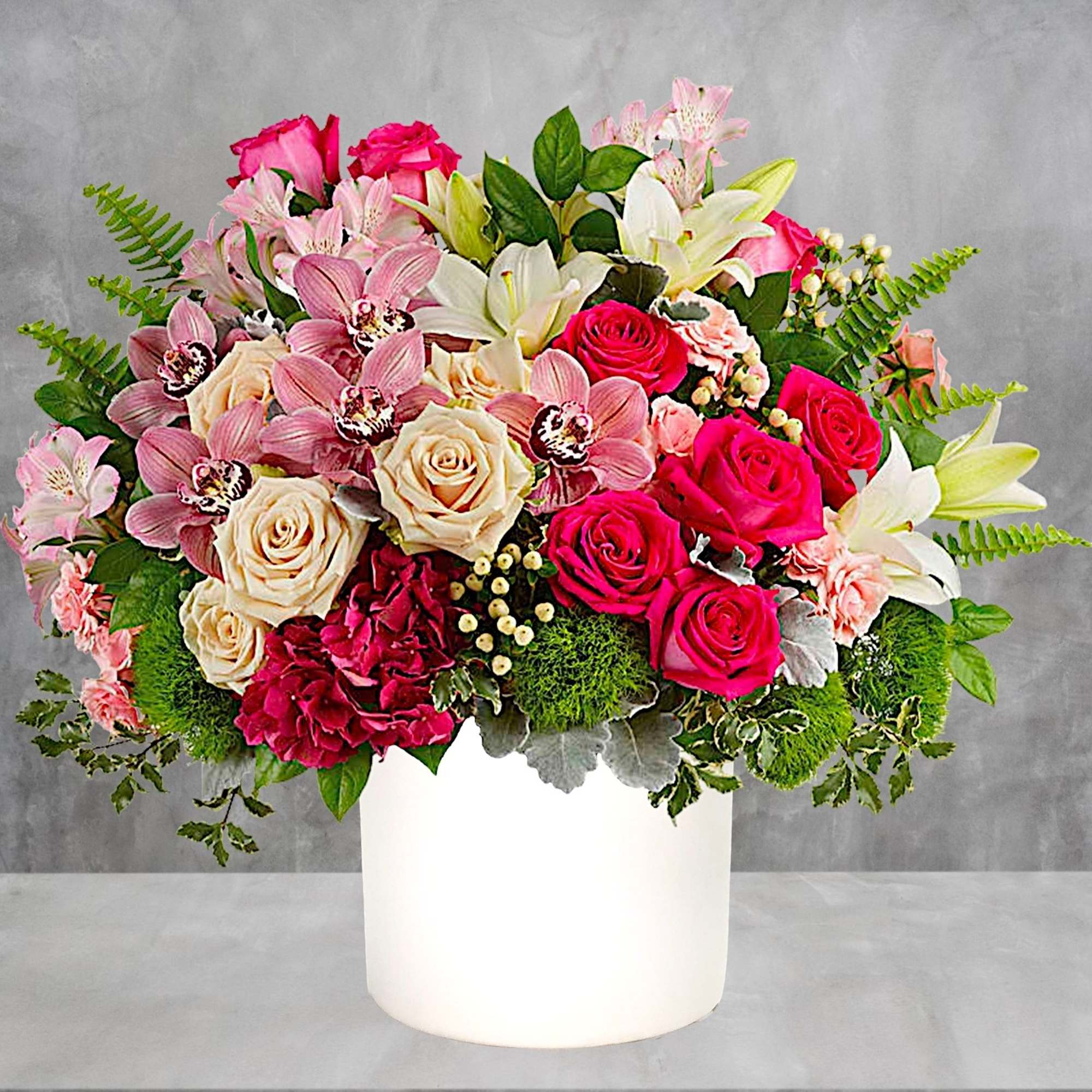 Mixed pink and white flowers arranged in a white vase