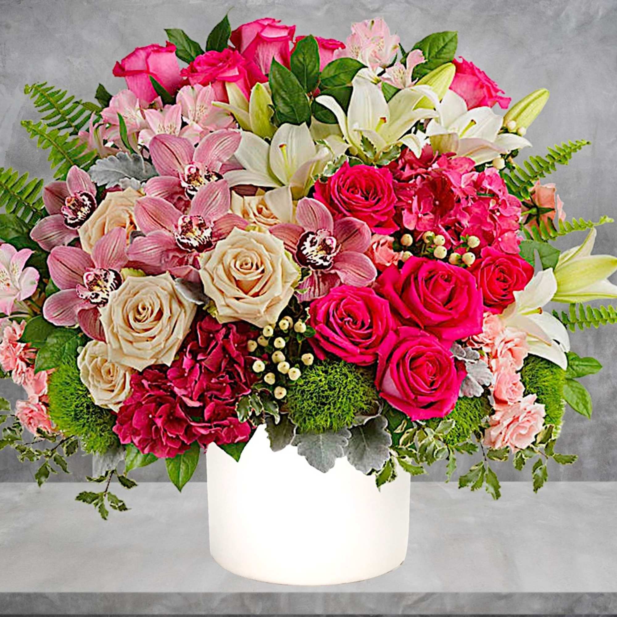 Mixed bouquet of pink and white flowers in a white vase