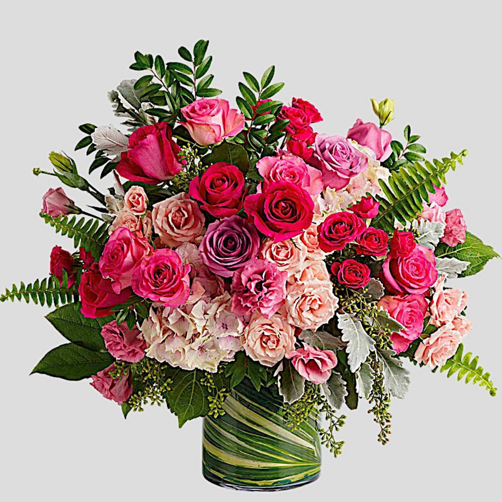Pink and peach rose bouquet in a green glass vase