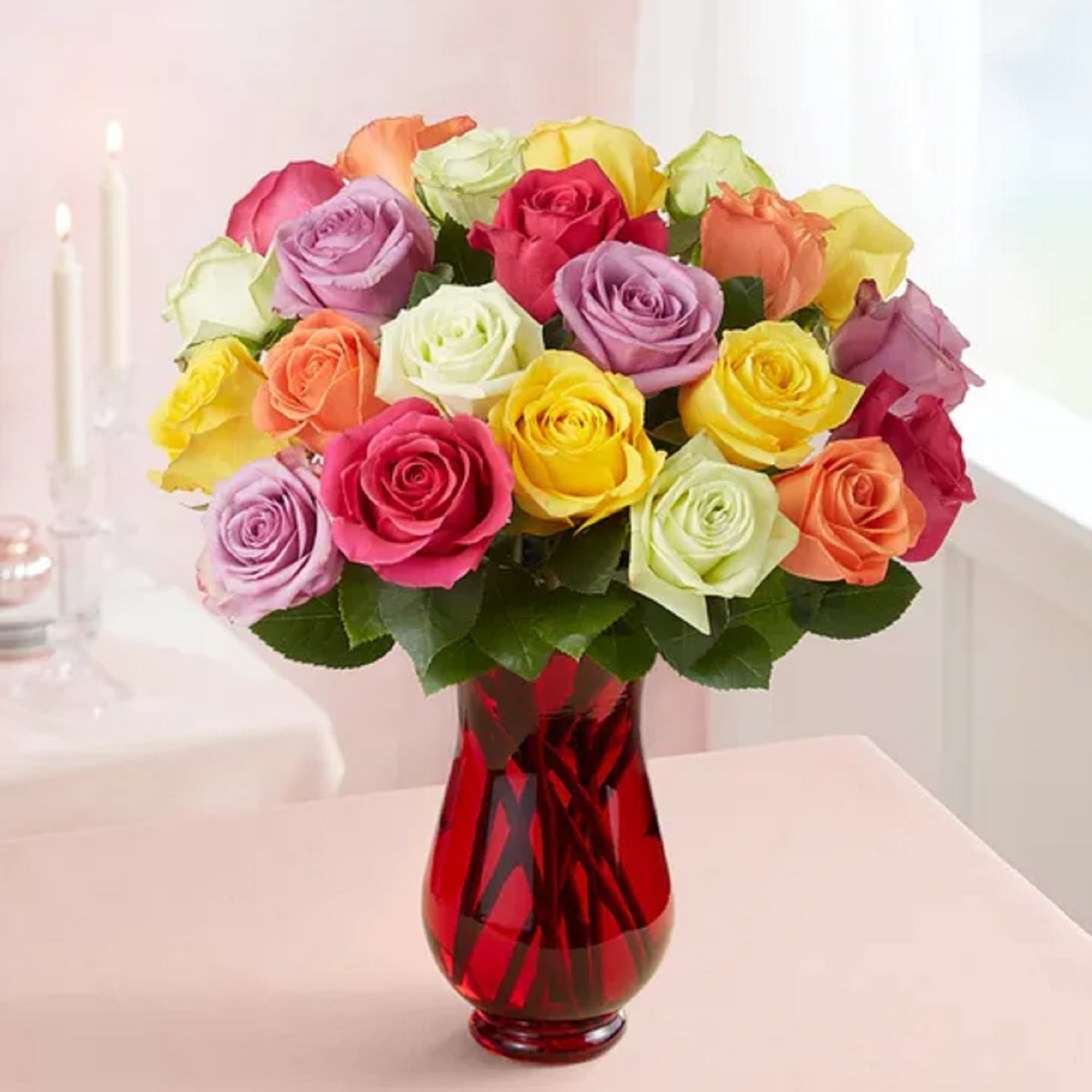 Multicolored roses arranged in a red glass vase