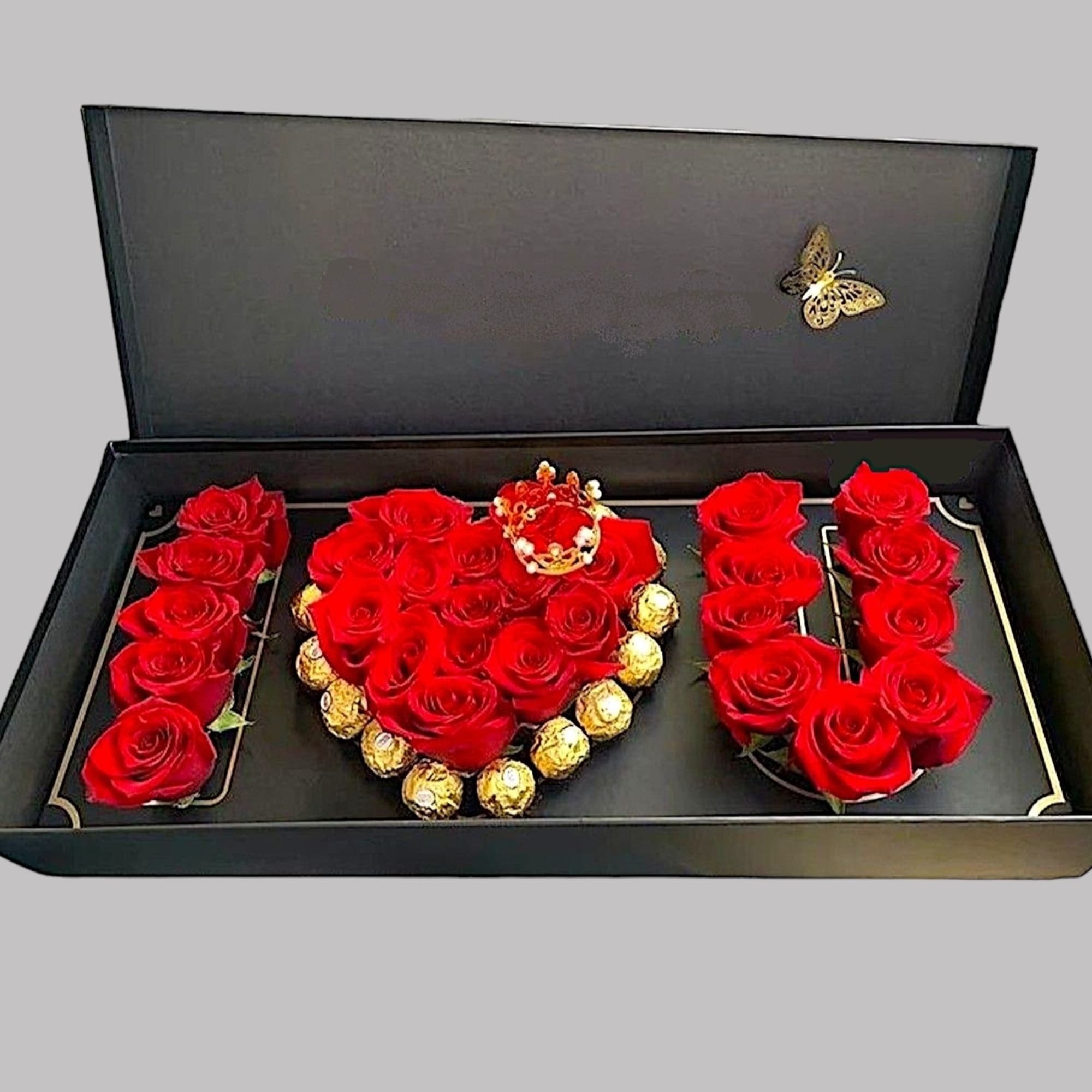 Red roses arranged in a gift box spelling "I U" with chocolates