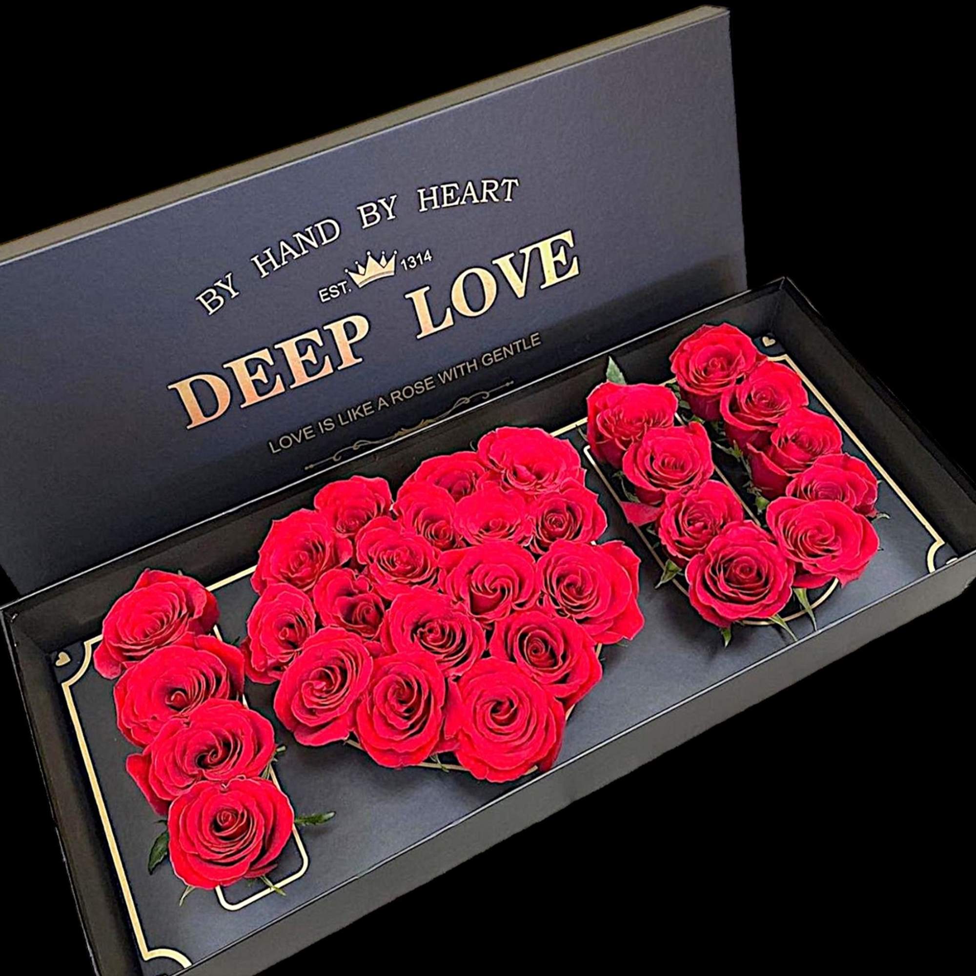 Red roses arranged in a black gift box with gold lettering