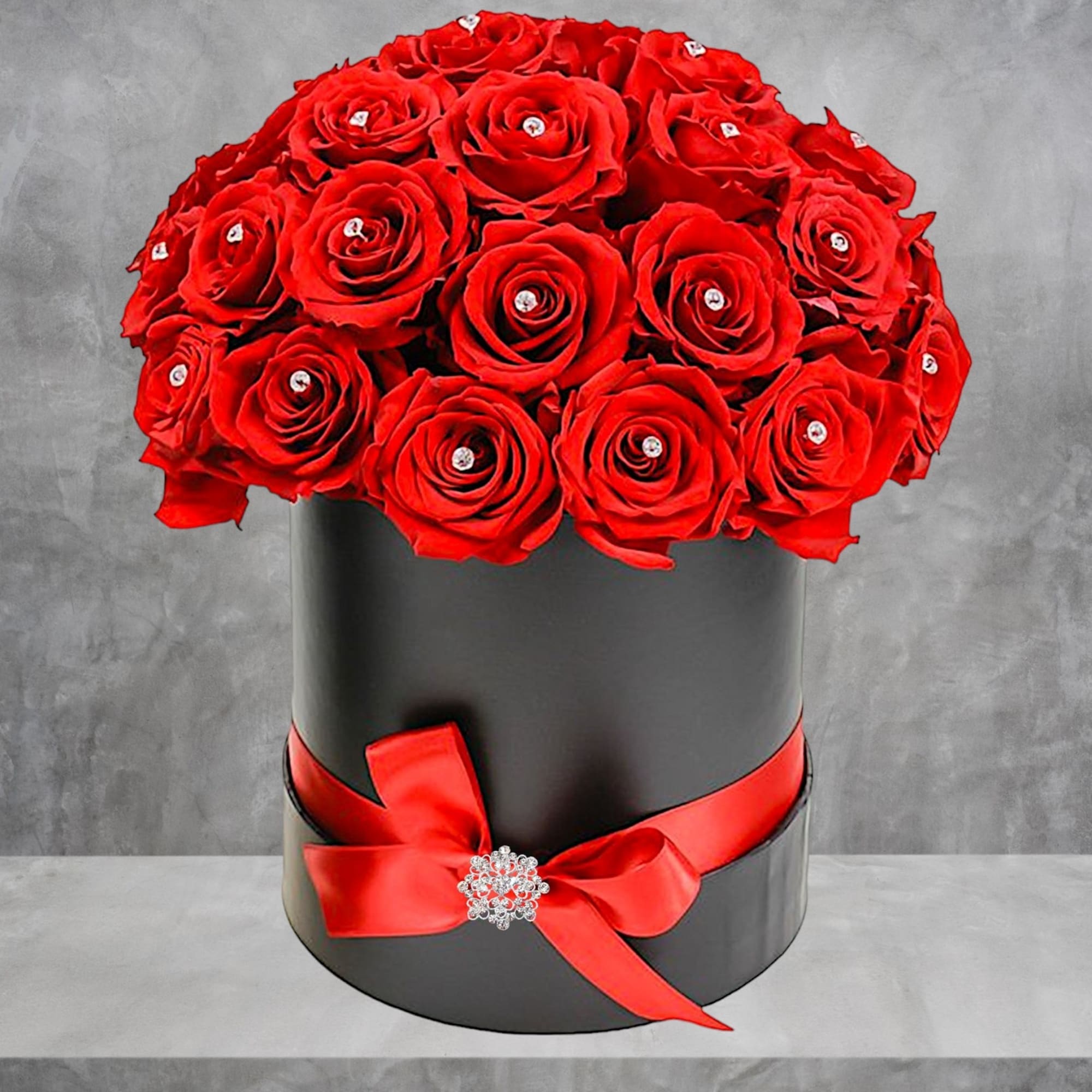 Red roses arranged in a black round box with a red ribbon