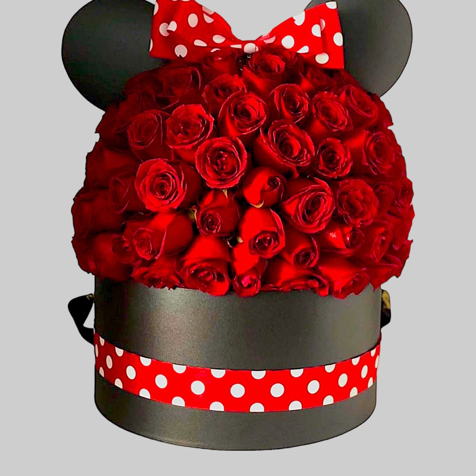 Red rose arrangement in a black round box with a polka-dot bow