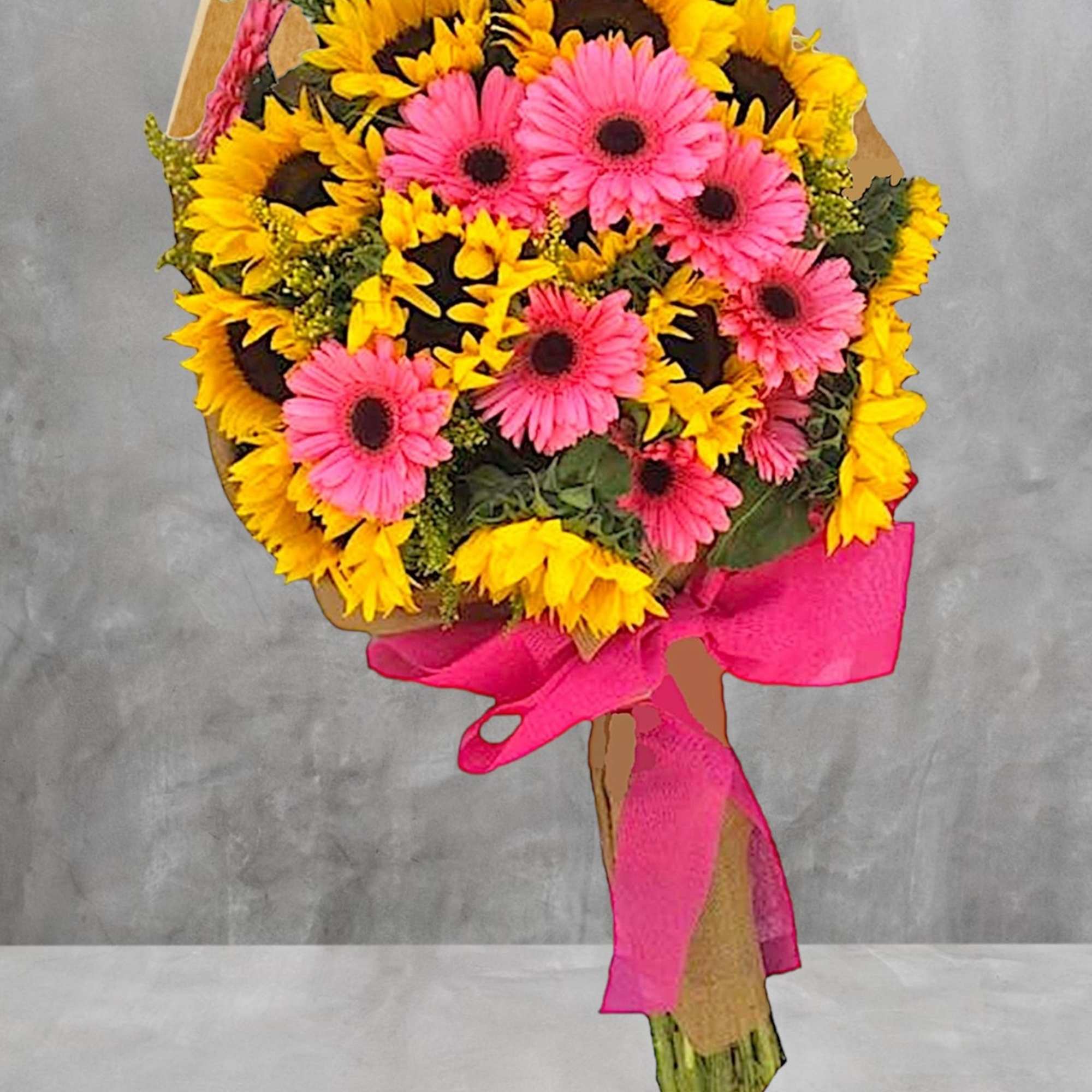 Bouquet of pink gerbera daisies and yellow sunflowers wrapped with a pink ribbon