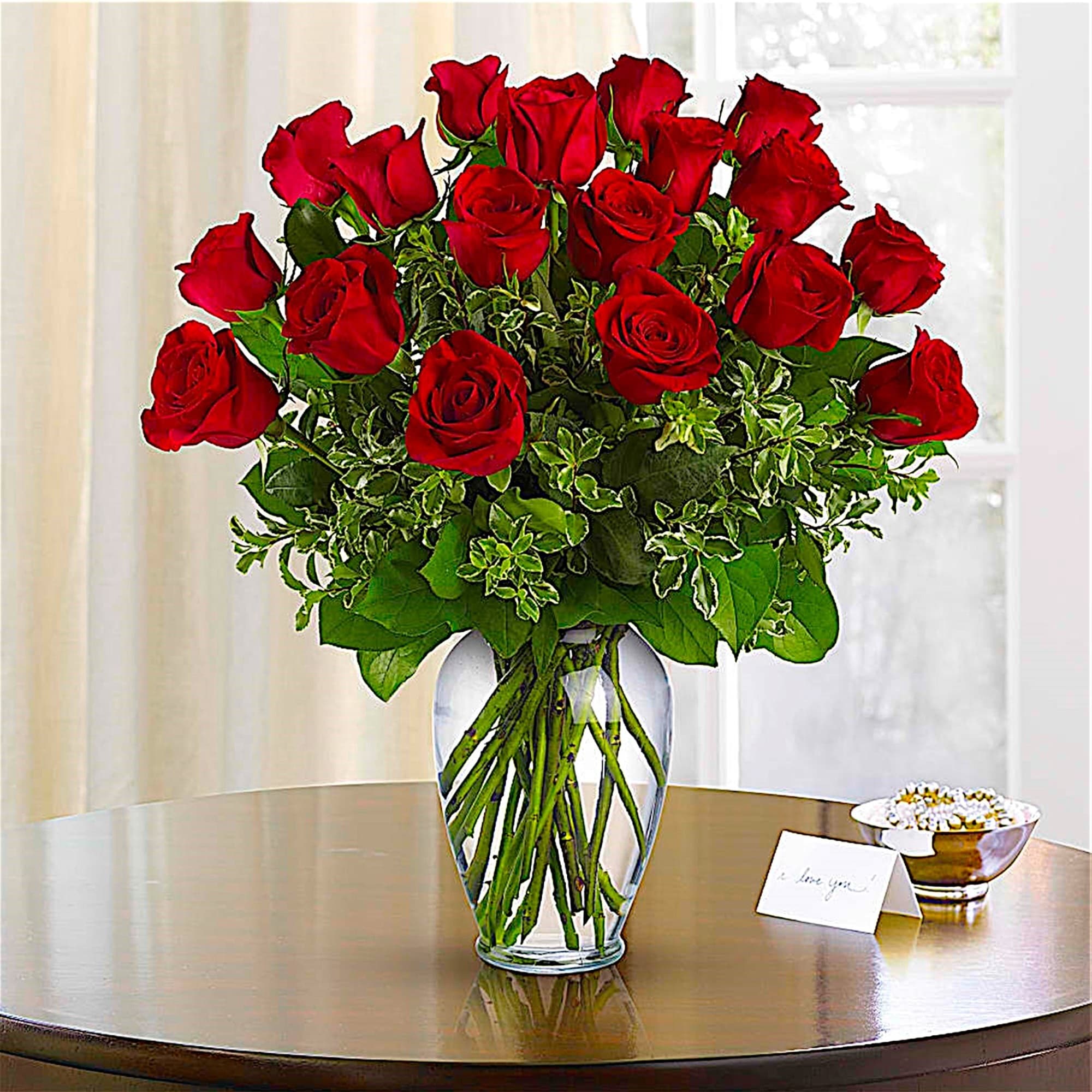 Bouquet of red roses in a clear glass vase on a table