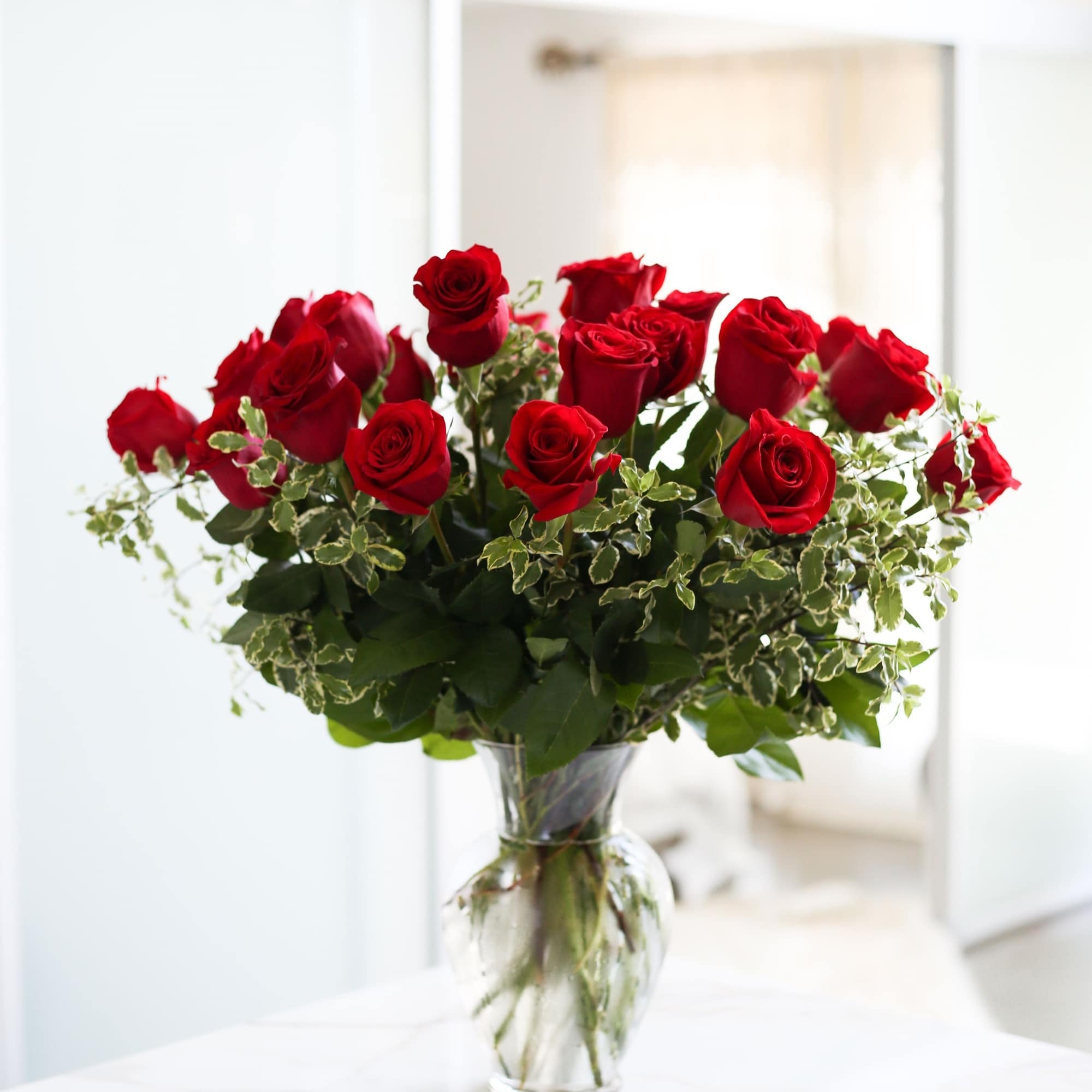 Red roses arranged in a clear glass vase, photo 6 of 8