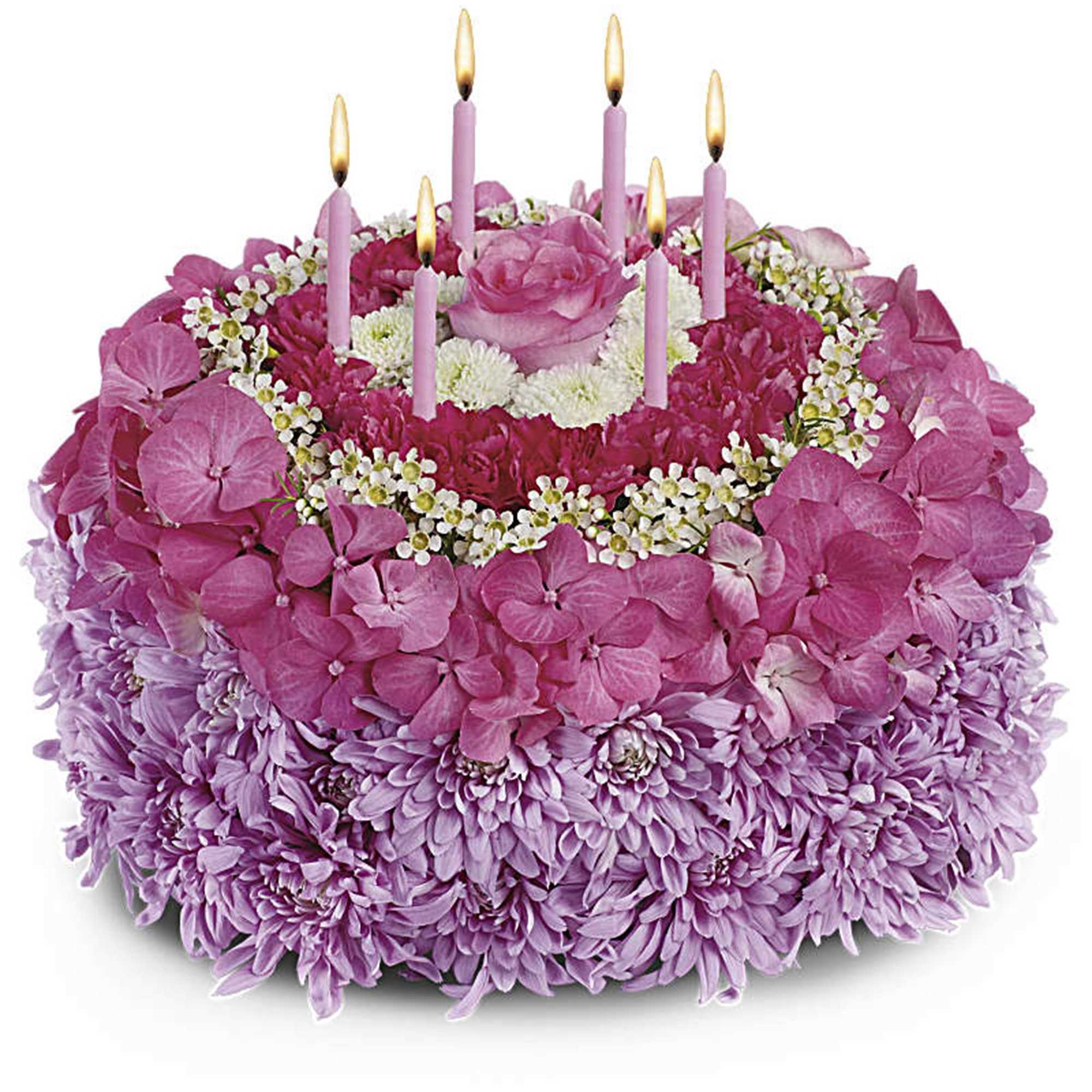 Pink and lavender floral cake with lit candles