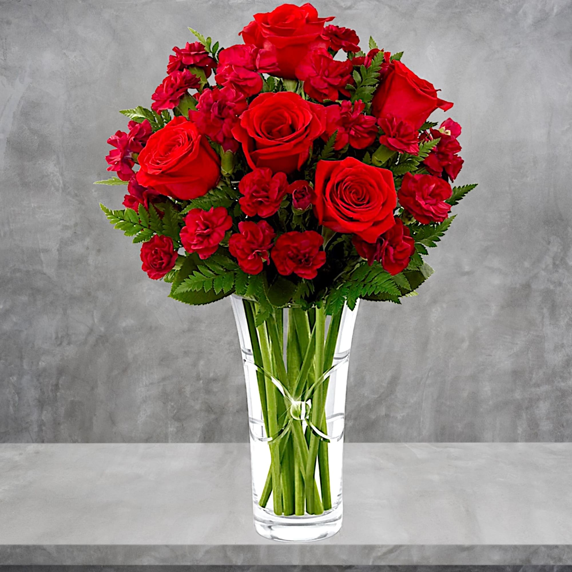 Red roses and red carnations in a clear glass vase, photo 2 of 5