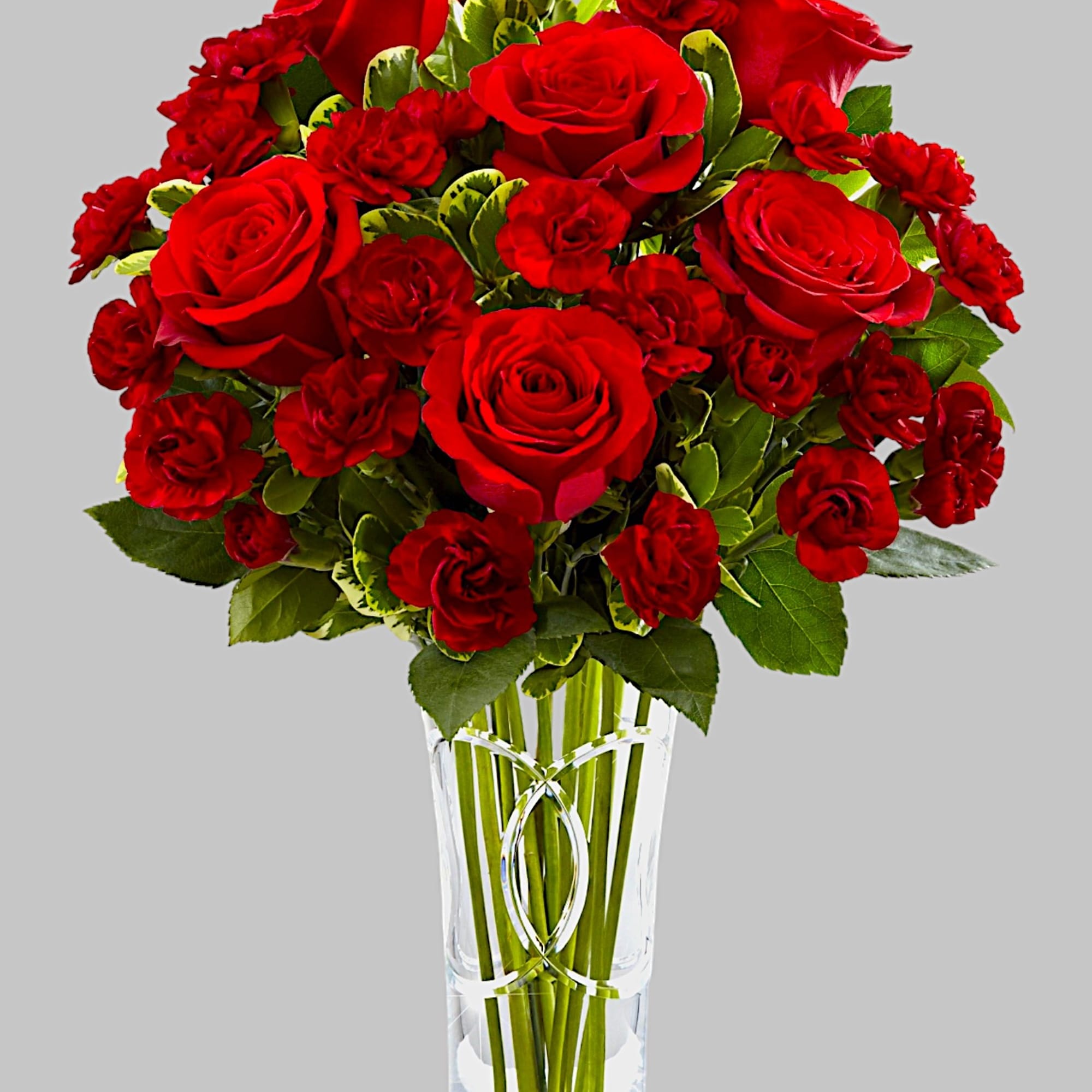 Red roses arranged in a clear glass vase