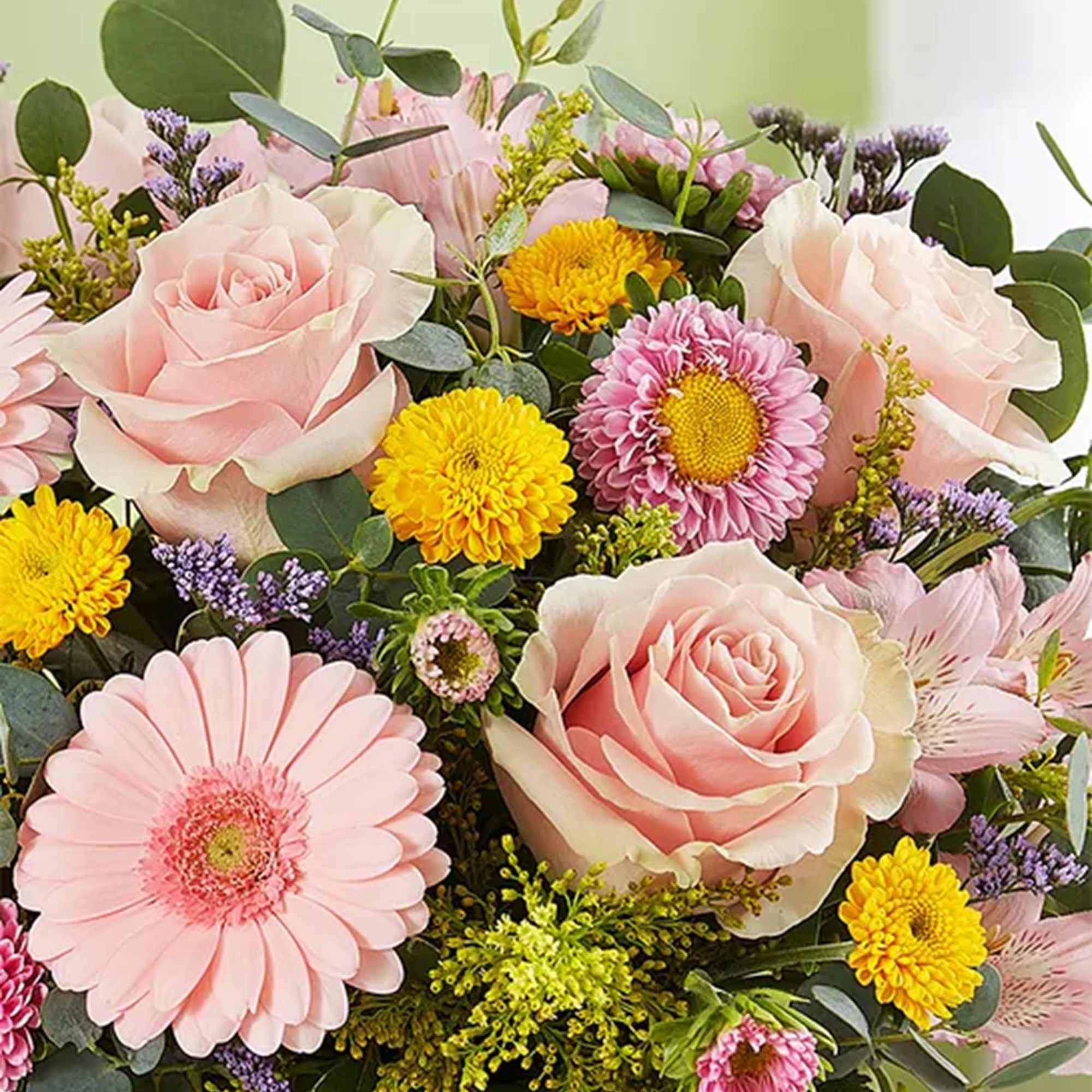 Bouquet of pale pink roses and daisies with yellow and purple accents