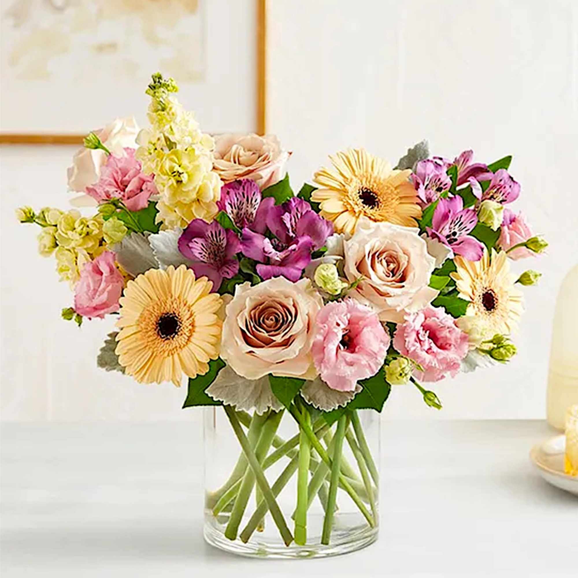 Mixed bouquet of roses, gerbera daisies, and pink blooms in a clear glass vase, photo 3 of 6