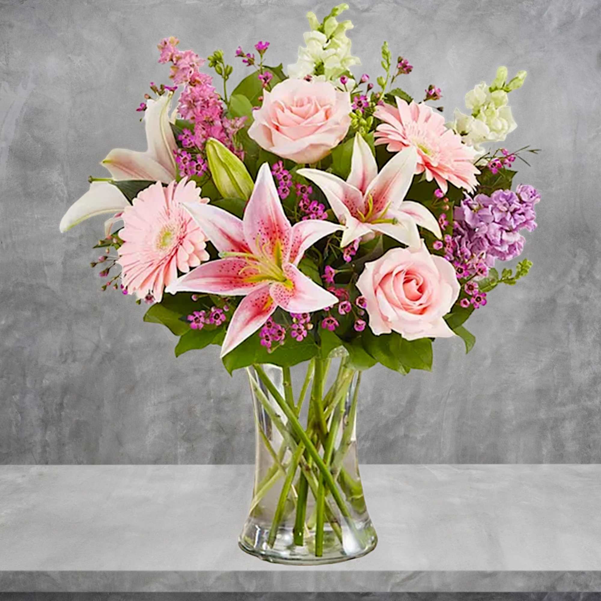 Pink roses and lilies arranged in a clear glass vase, photo 2 of 6
