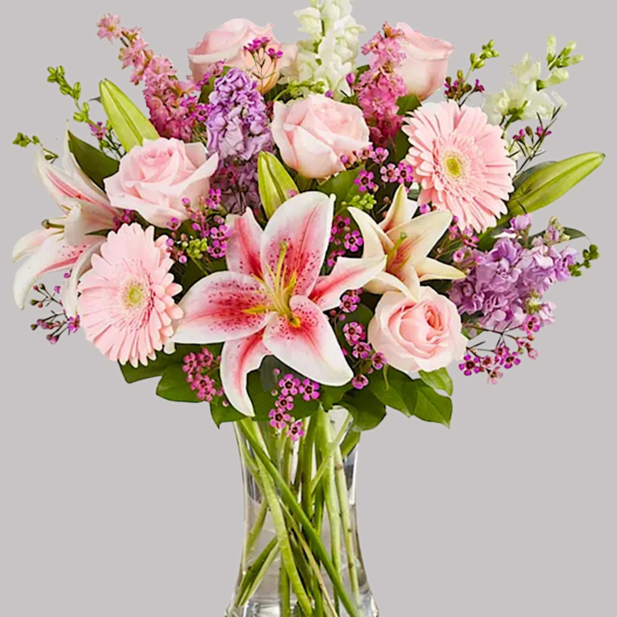Pink roses and lilies in a clear glass vase