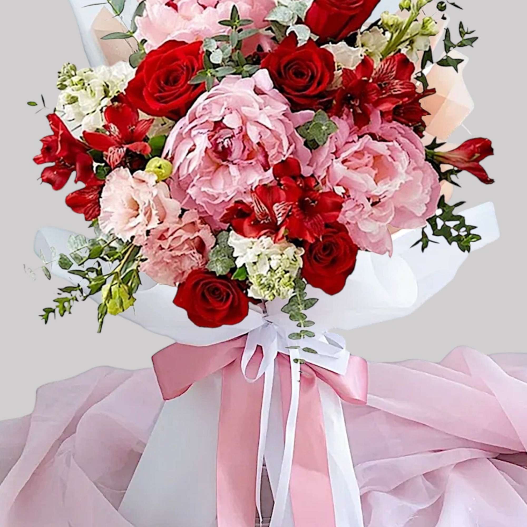 Bouquet of pink peonies and red roses with ribbon wrap