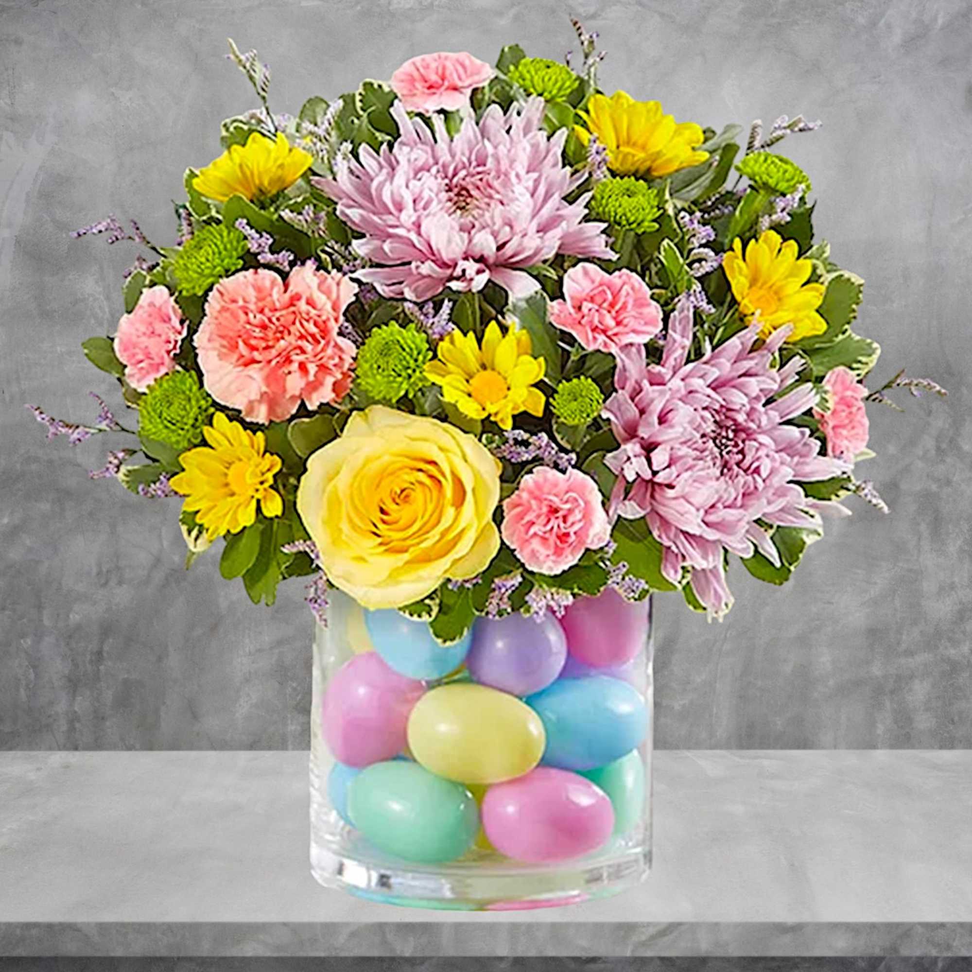 Mixed bouquet in a glass vase filled with pastel eggs